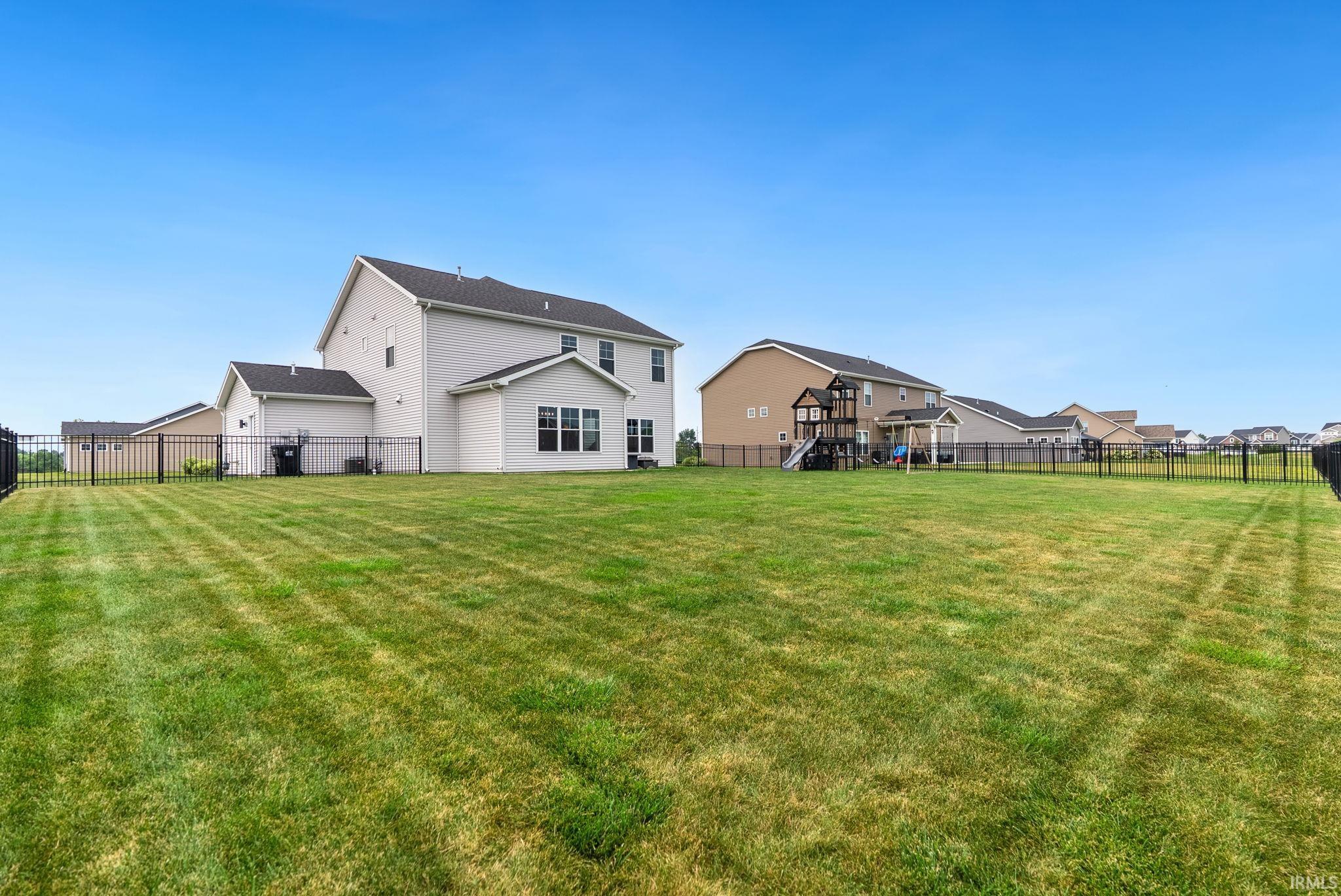 Expansive fenced yard with a manicured lawn