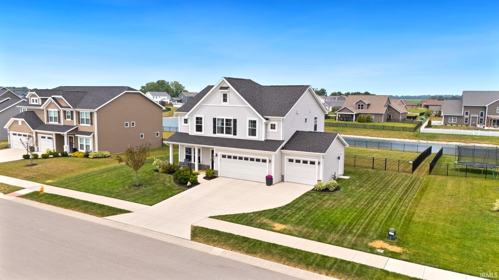 Contemporary two-story residence with light gray siding and dark shutters