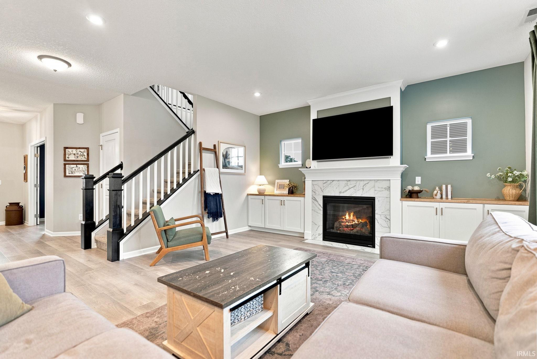 Living area with a fireplace featuring a stone surround and a white mantel