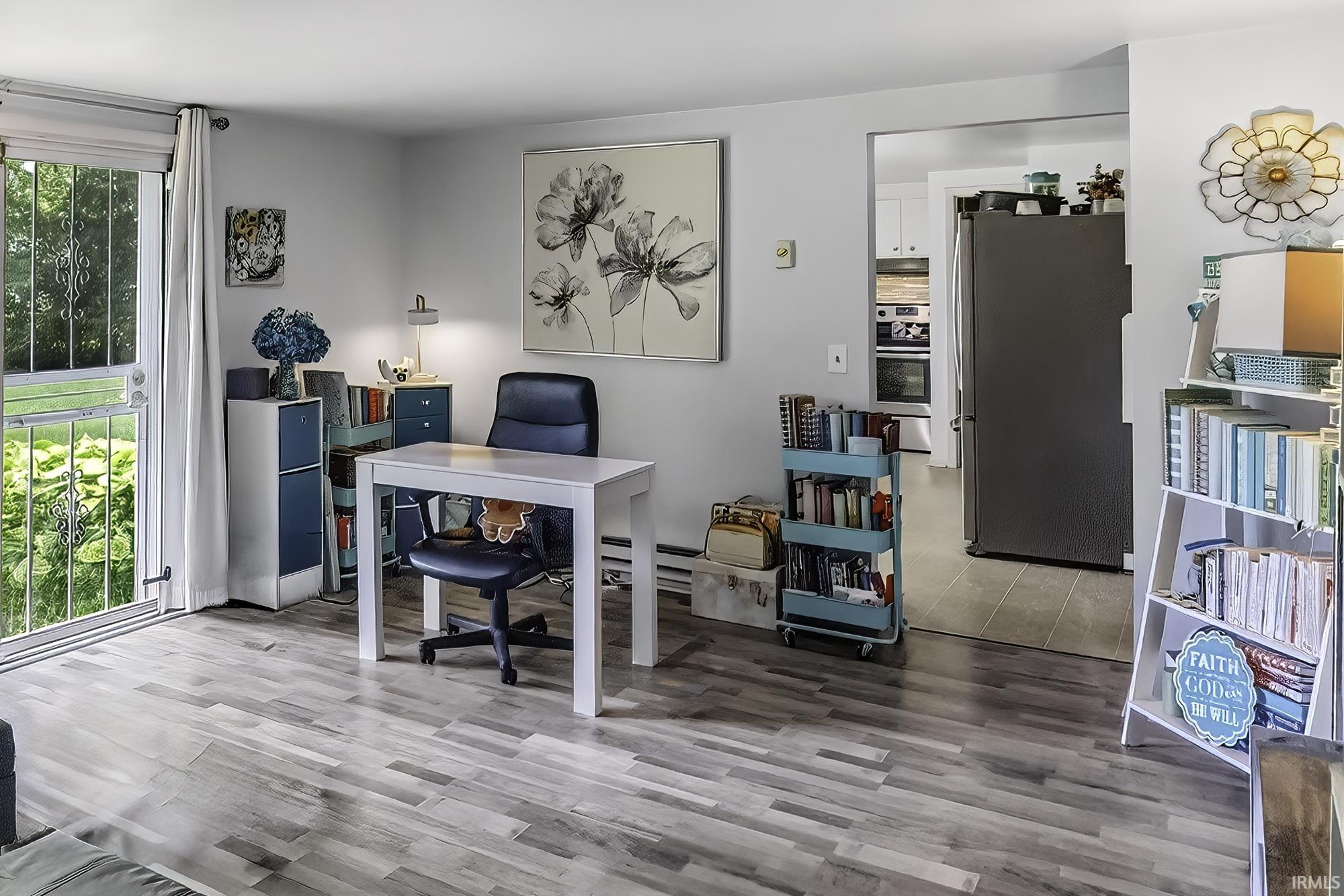 Light wood-finish flooring extending from the main area into an adjacent kitchen