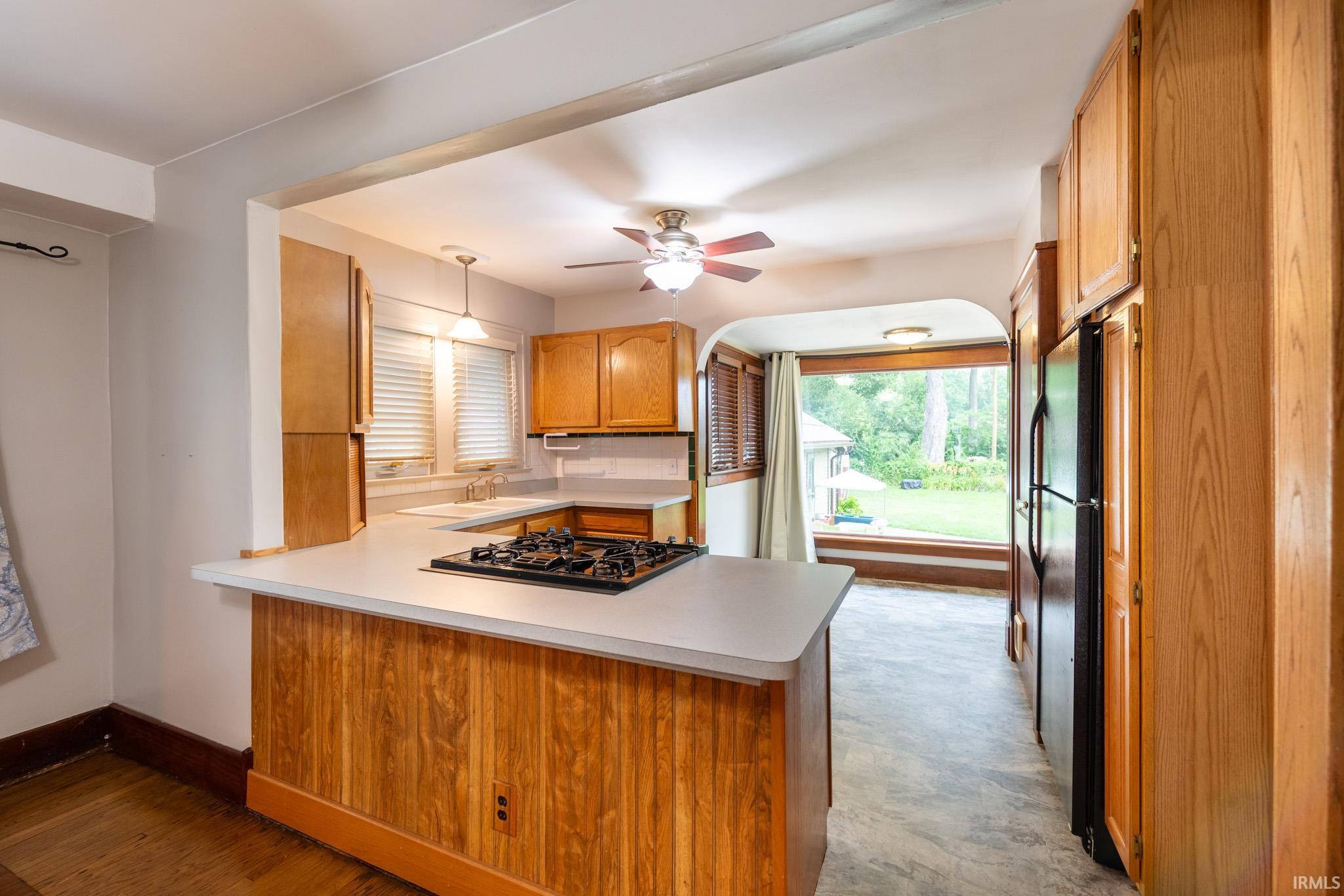 Kitchen featuring wood cabinetry, light-toned countertops, and a built-in gas range