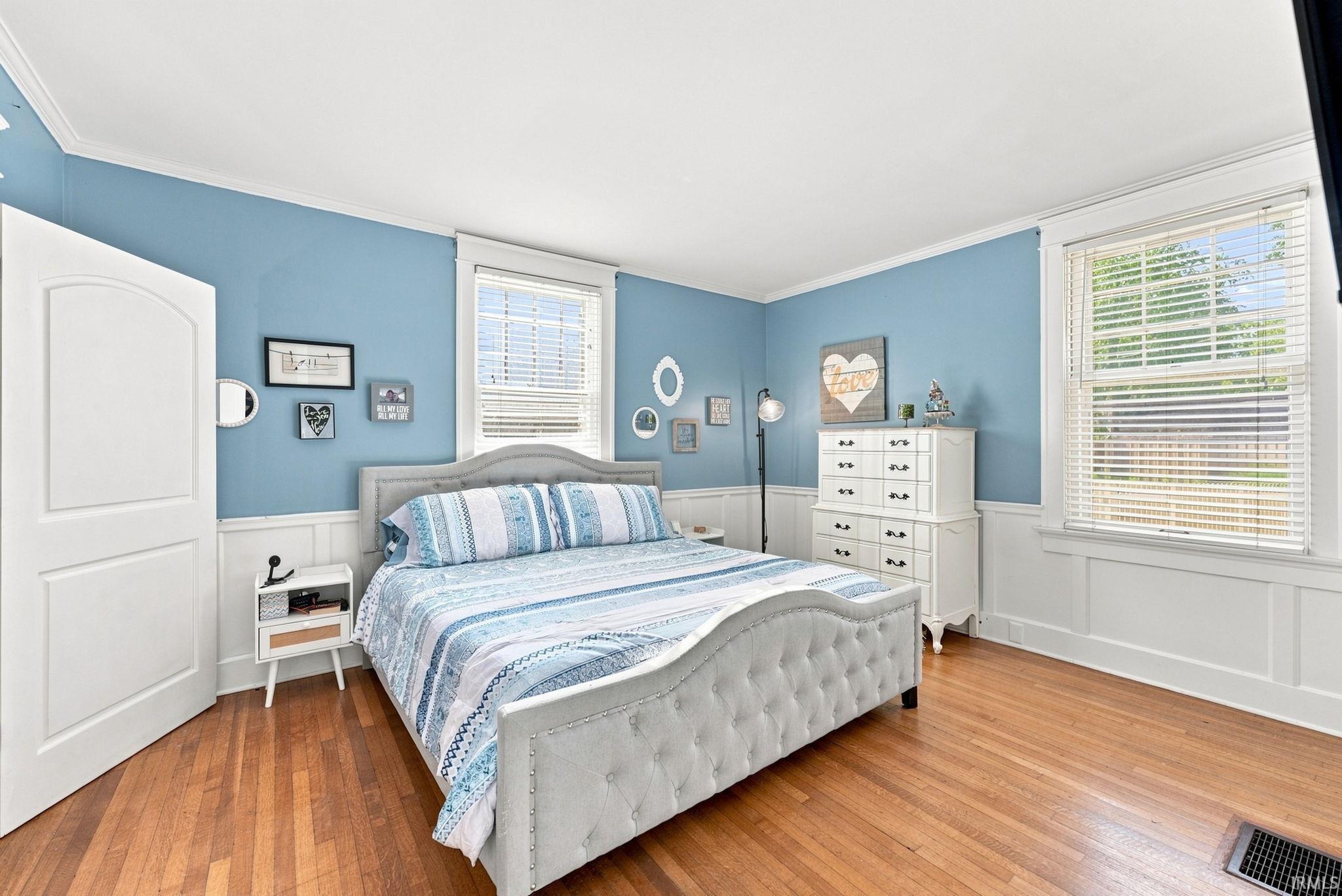 Hardwood flooring paired with wainscoting and crown molding