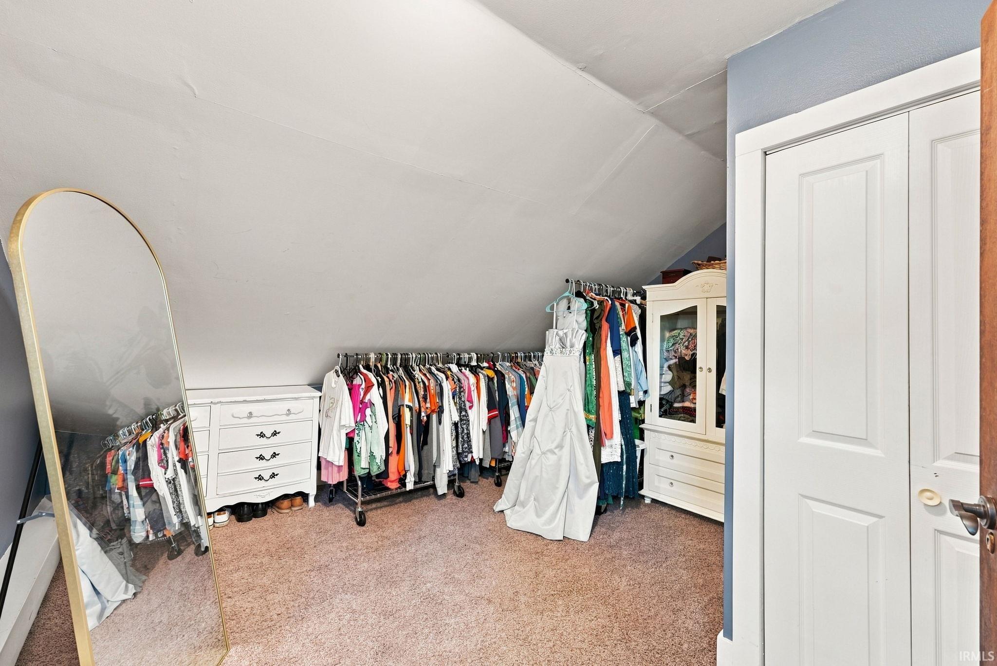 Carpeted room with sloped ceilings and light blue wall accents
