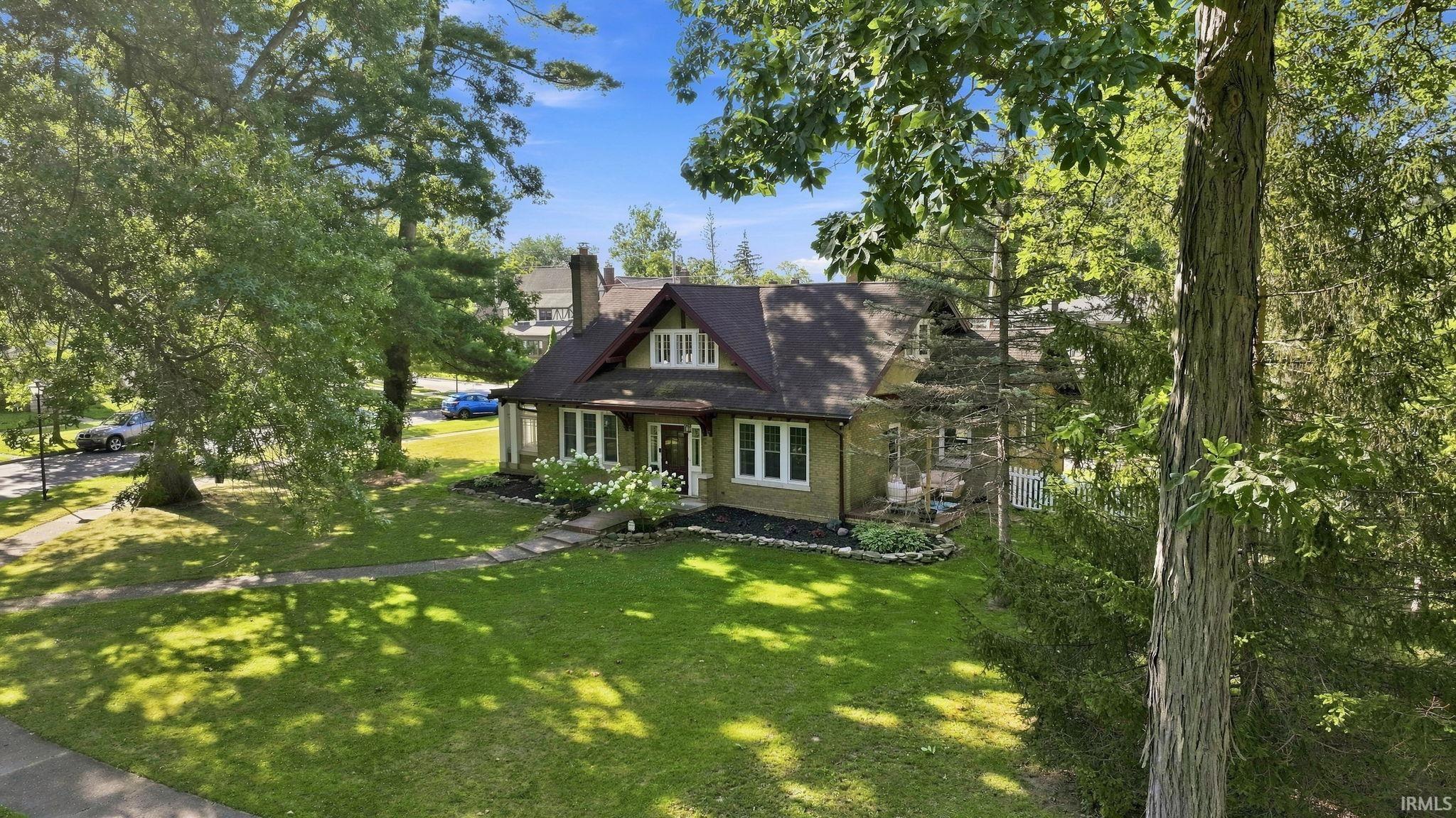 Craftsman-style residence featuring a prominent gabled roofline and a stone chimney