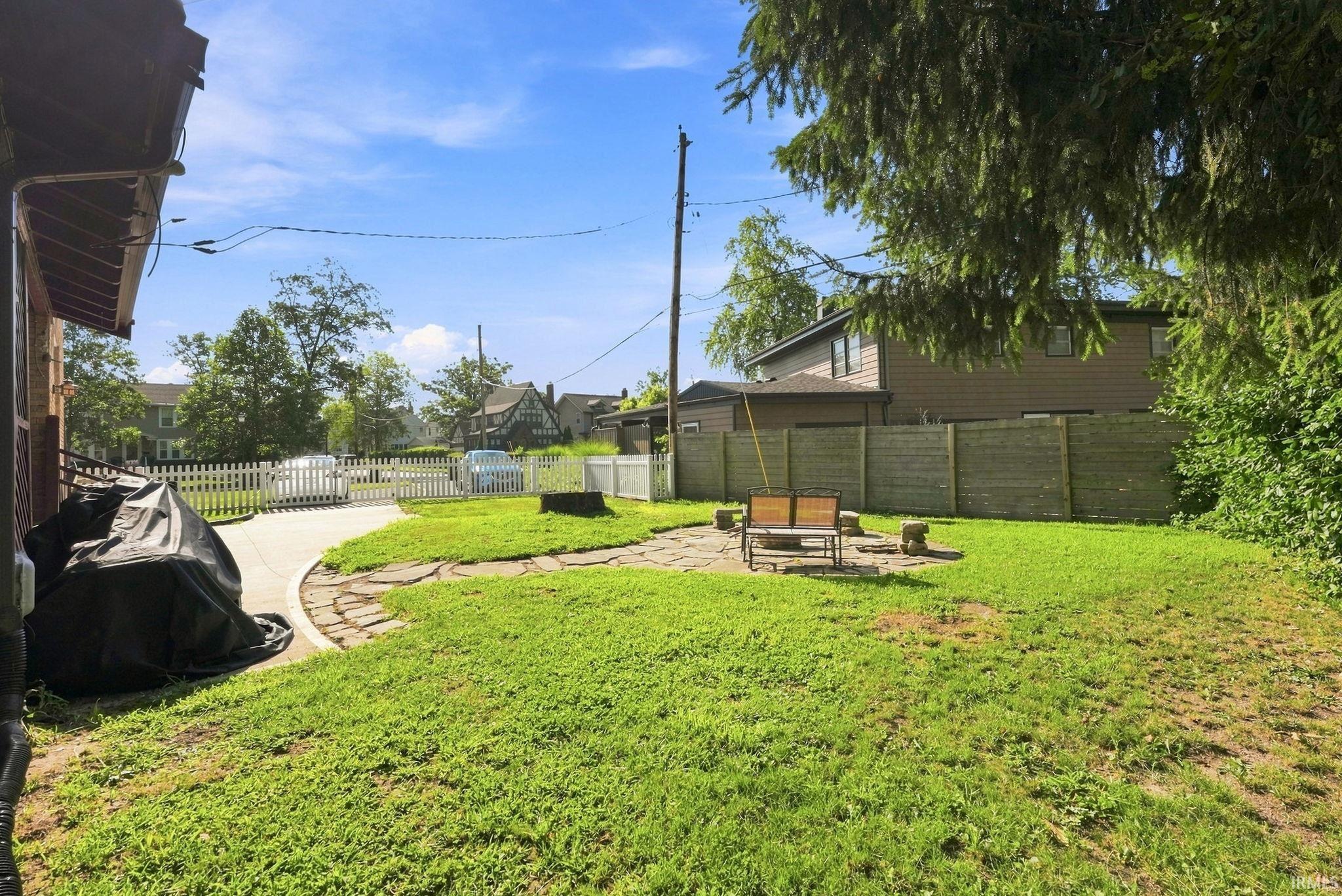 Private backyard with a flagstone patio area and surrounding lawn
