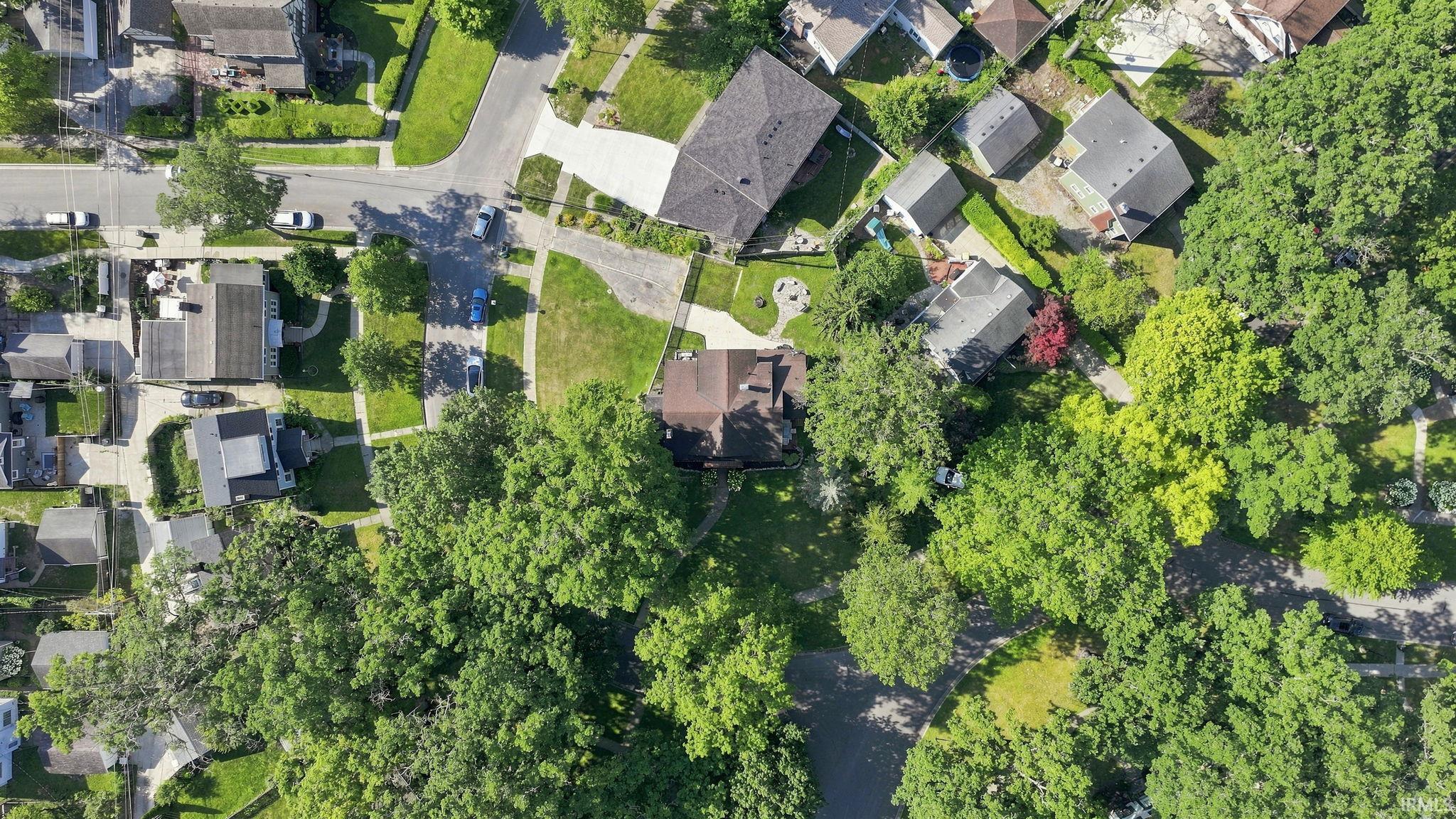 Aerial perspective showcasing a residential neighborhood with mature trees and established properties