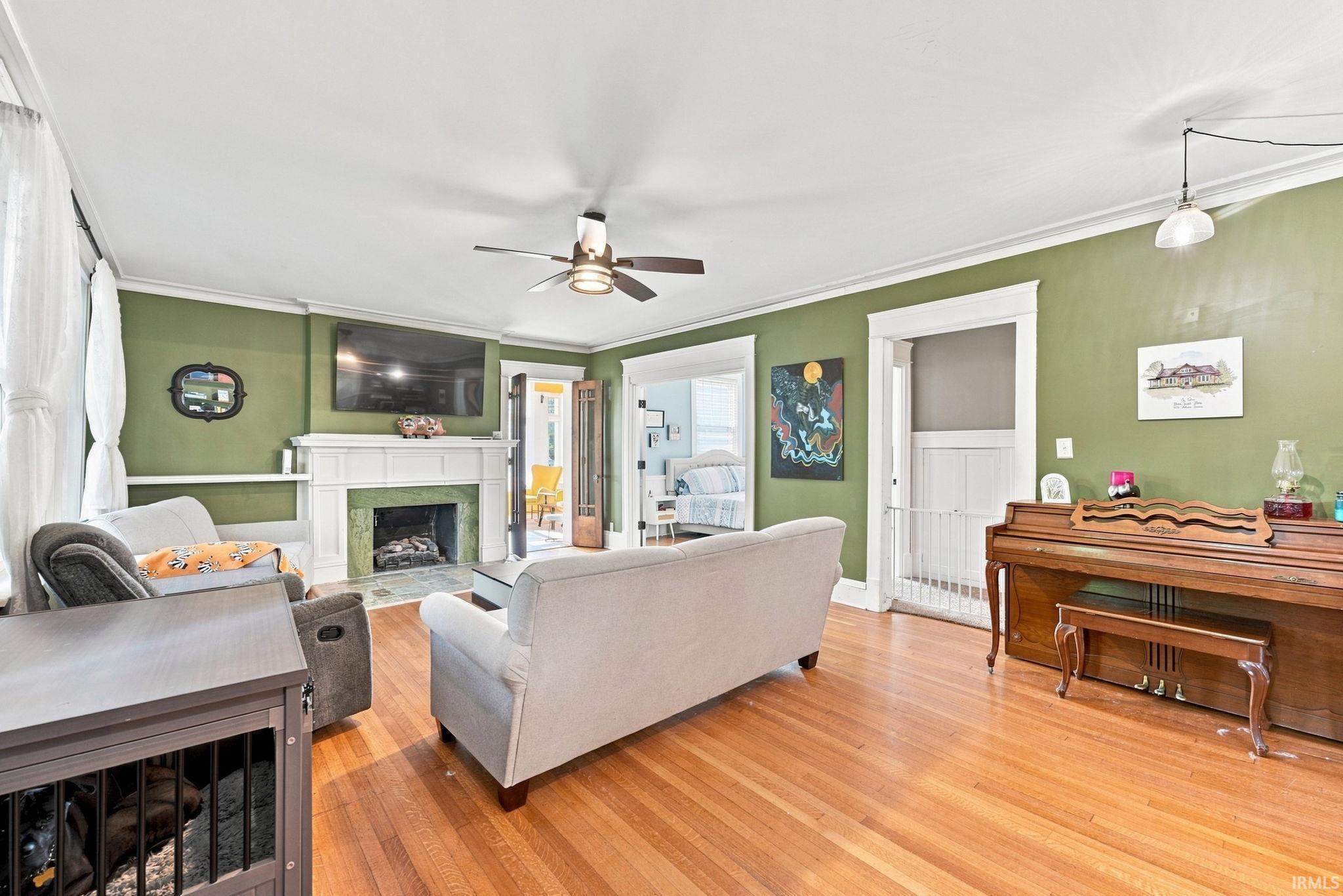 Living area showcasing wood-finish flooring and a ceiling fan