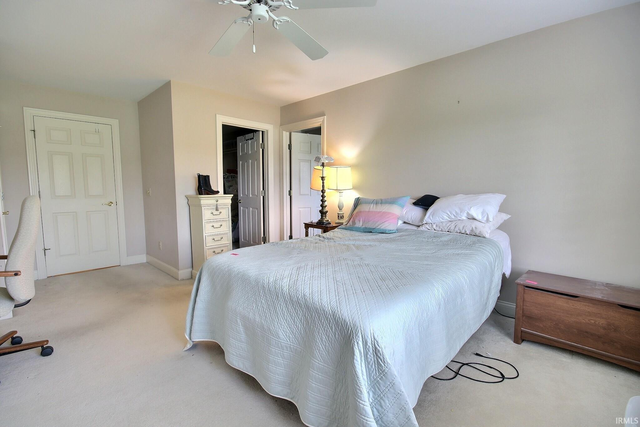 Carpeted bedroom featuring neutral wall paint and white trim