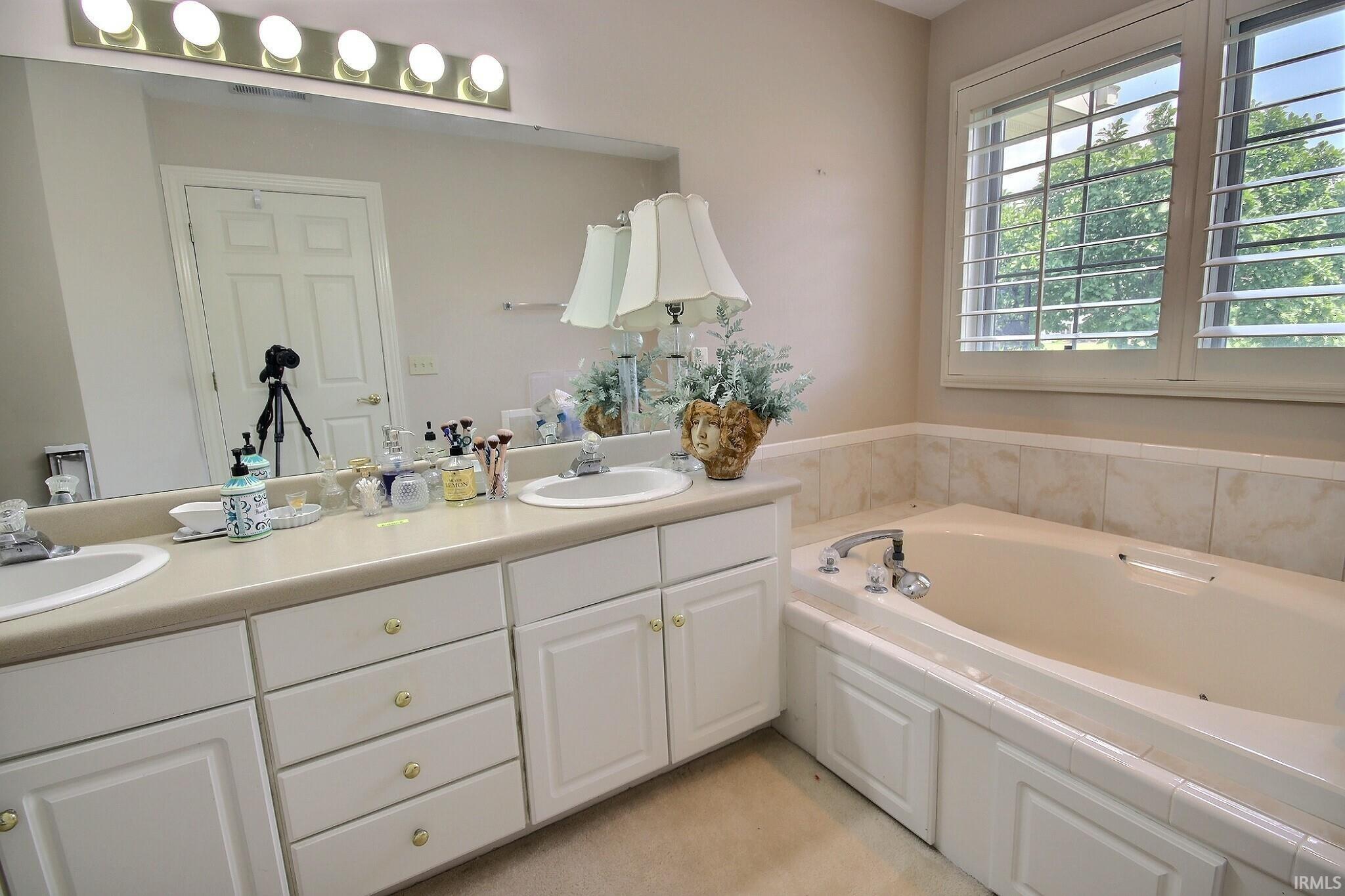 Dual vanity with integrated sinks, a large mirror, and a five-bulb light fixture