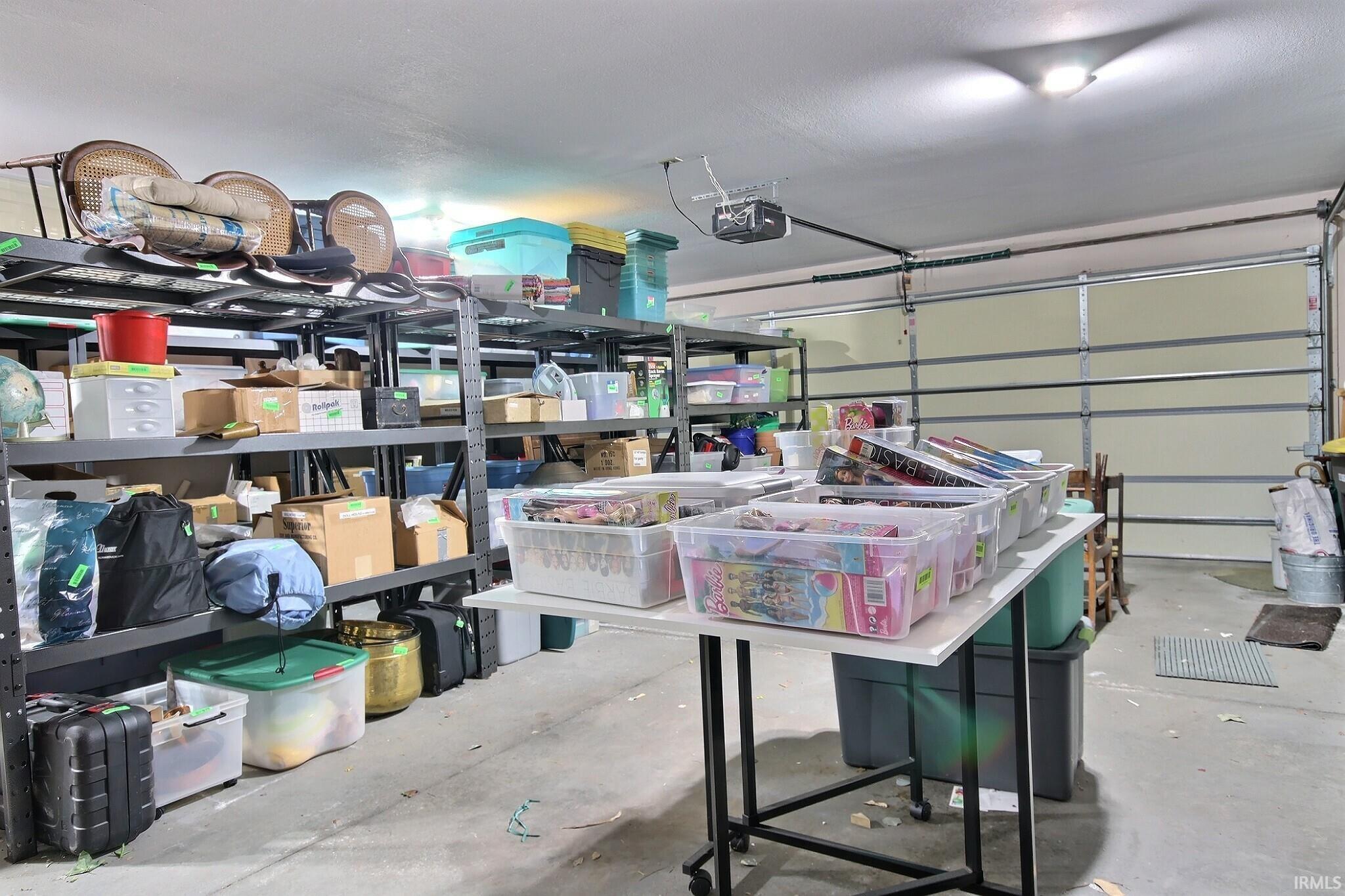 Spacious garage featuring a concrete floor, overhead lighting, and a roll-up garage door