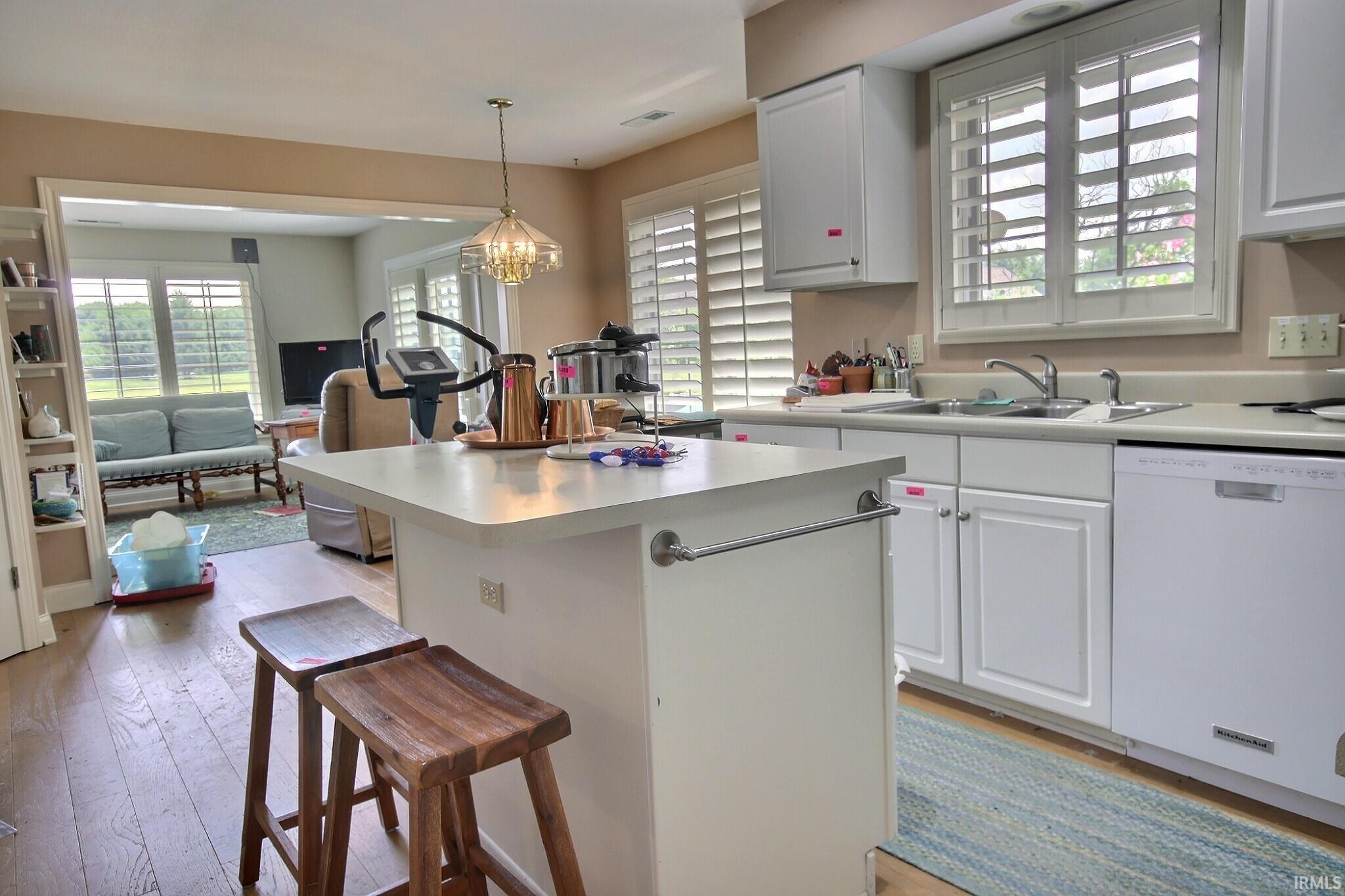 Kitchen featuring white shaker-style cabinetry, a built-in dishwasher, and a double-basin stainless steel sink