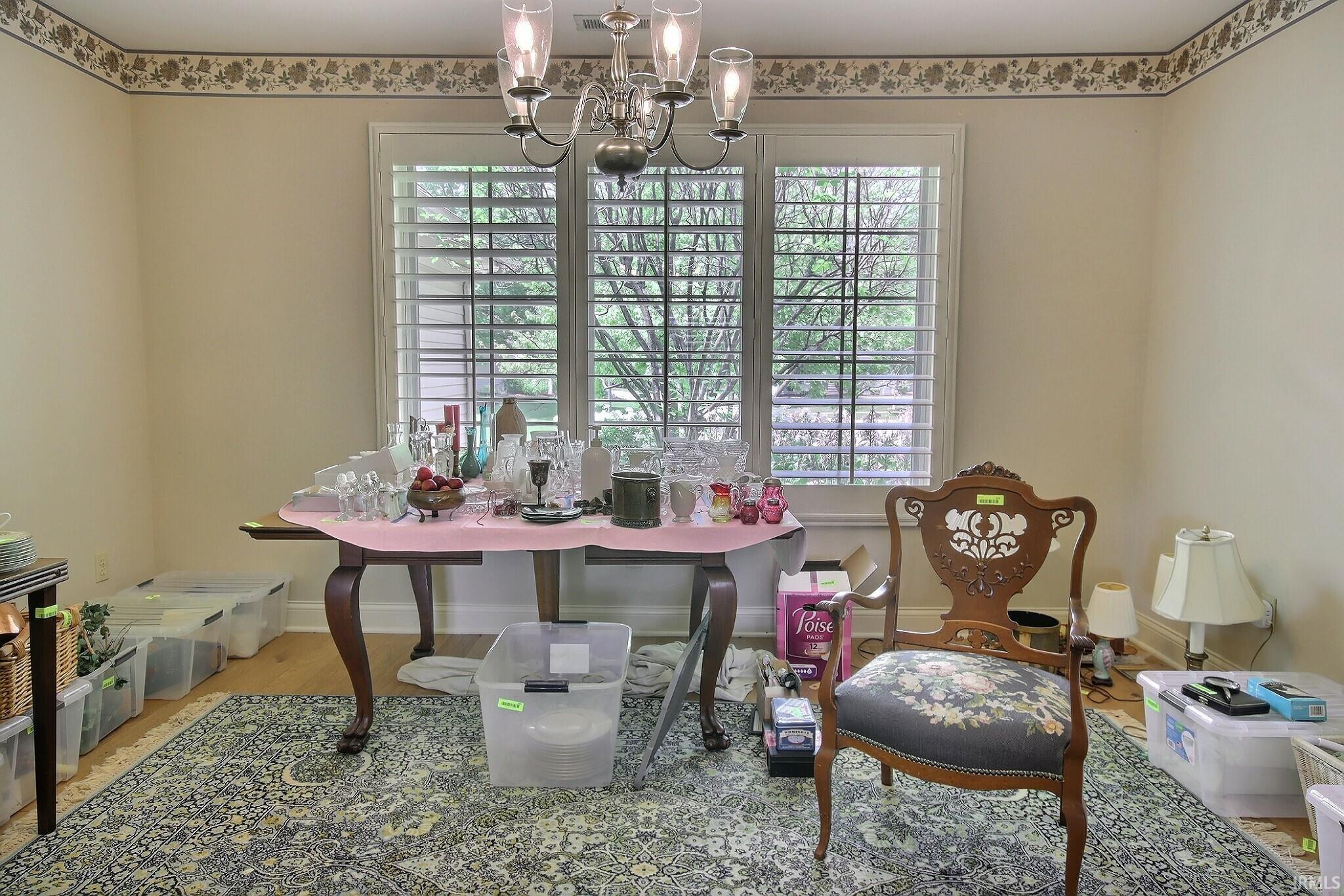 Hardwood flooring with an area rug, complemented by a decorative wallpaper border