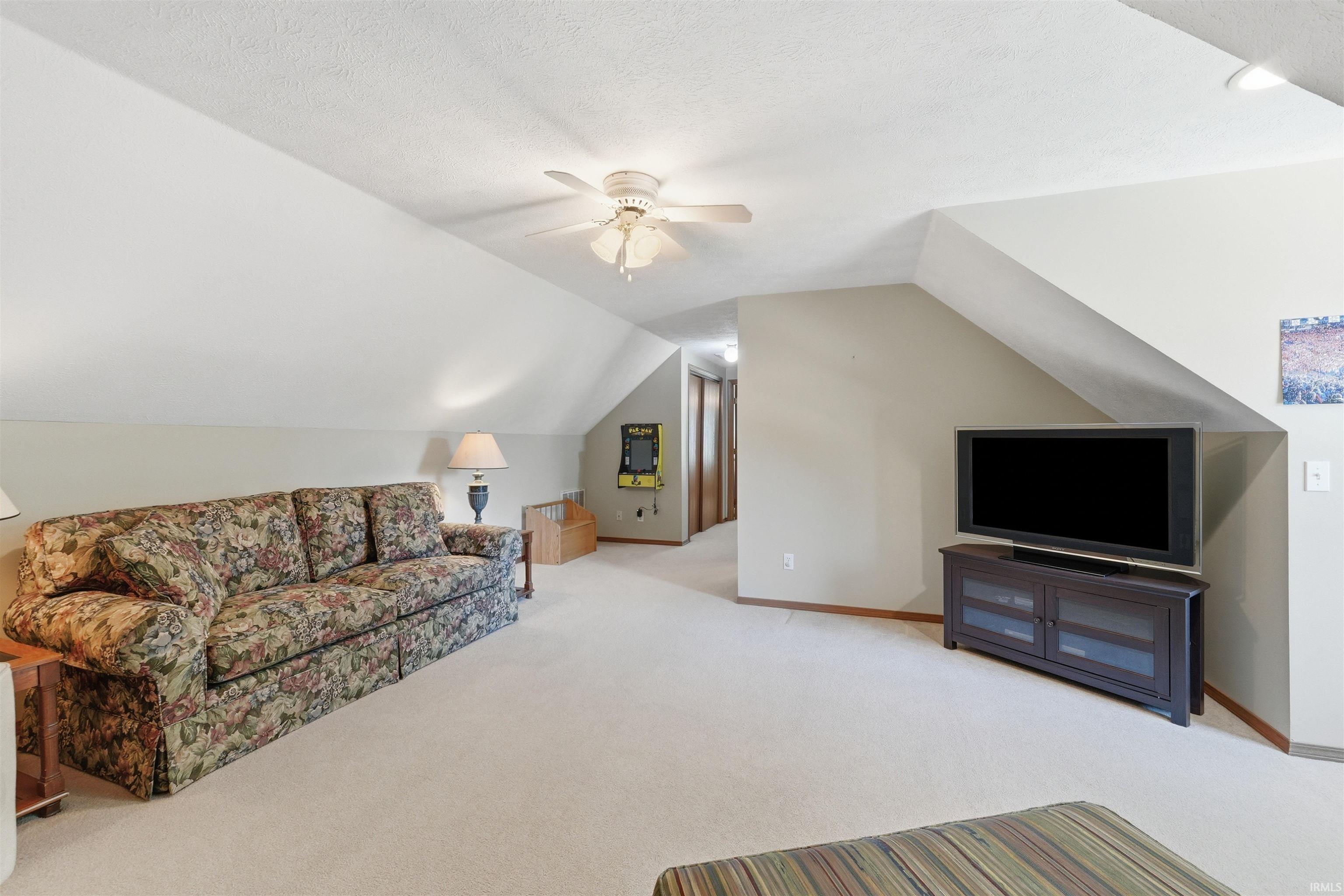 Carpeted room featuring a sloped ceiling, ceiling fan, and recessed lighting