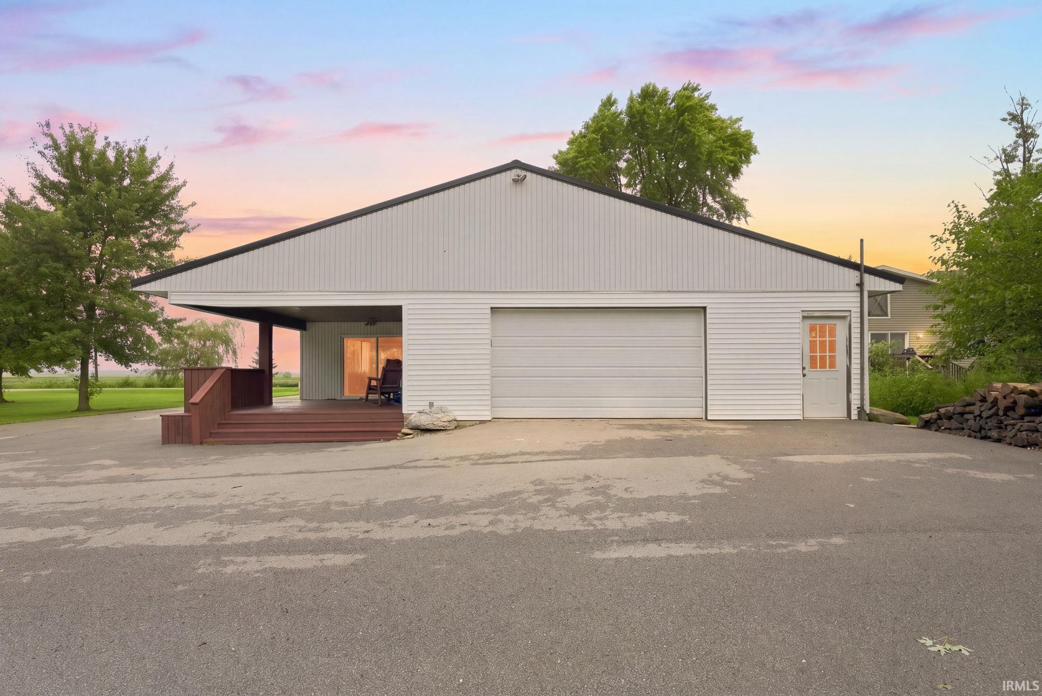 Spacious attached garage with an overhead door, covered porch, and exterior door access