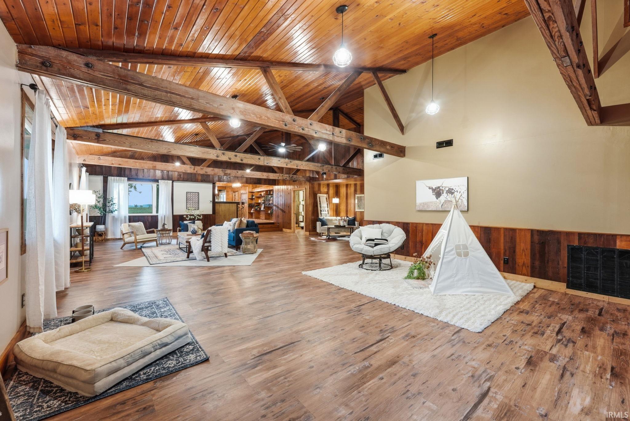Vaulted wood-paneled ceiling with exposed beams, wood-finish flooring, and recessed lighting