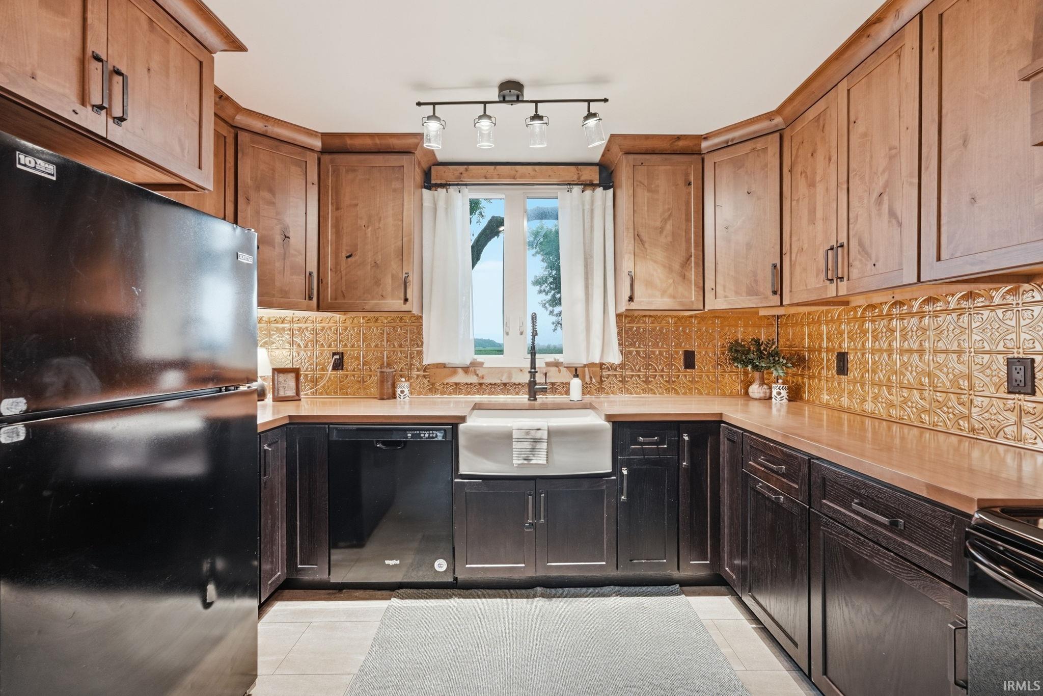 U-shaped kitchen with wood-finish upper cabinetry and dark wood-finish lower cabinetry
