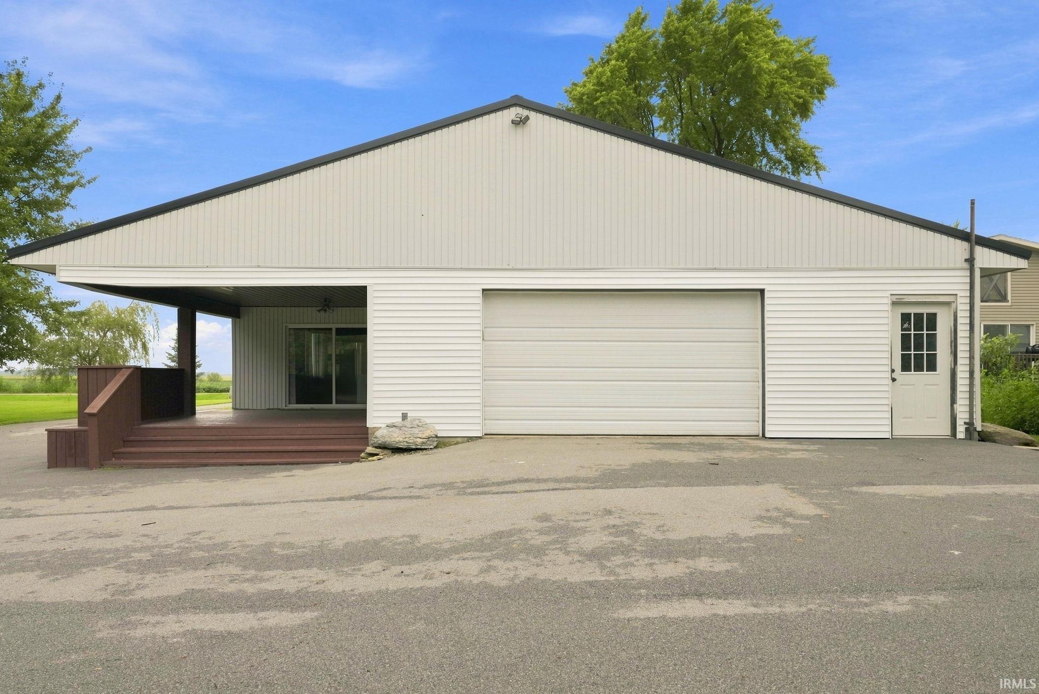 Attached garage door, dedicated access door, covered porch, sliding glass door, and a brown finished deck