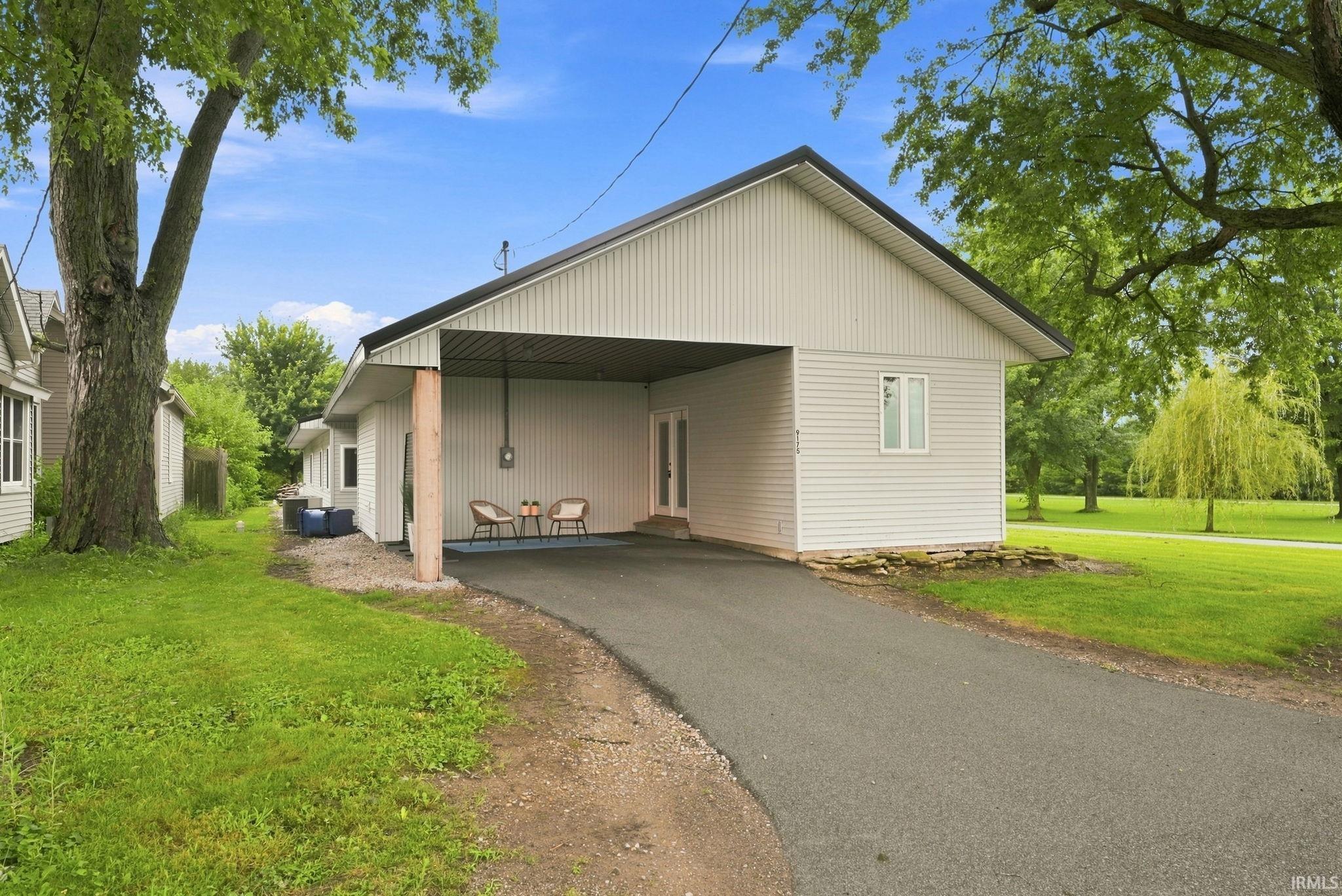 Paved driveway leading to a covered carport