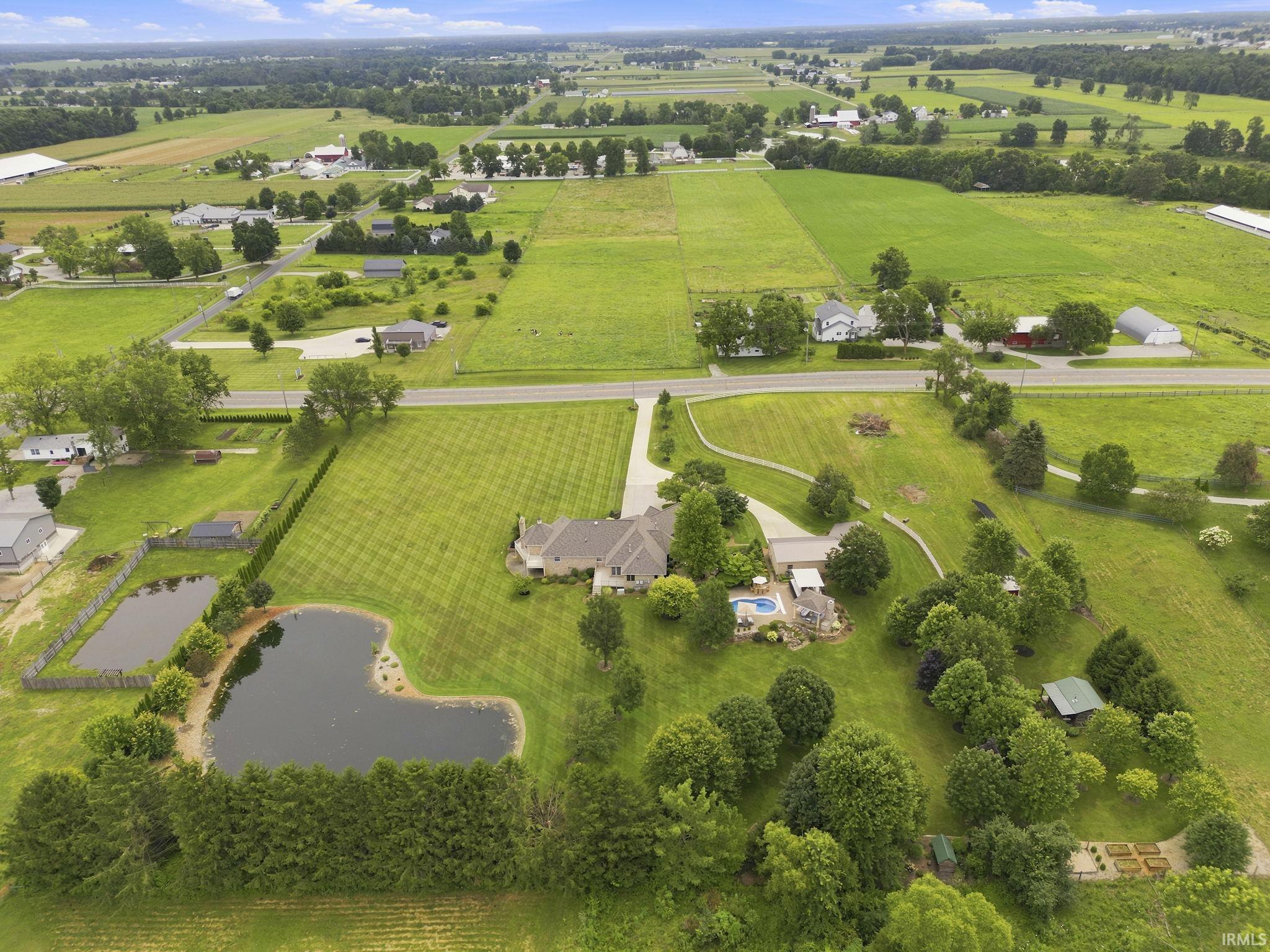 Aerial view showcasing the estate, private stocked pond, and picturesque grounds.