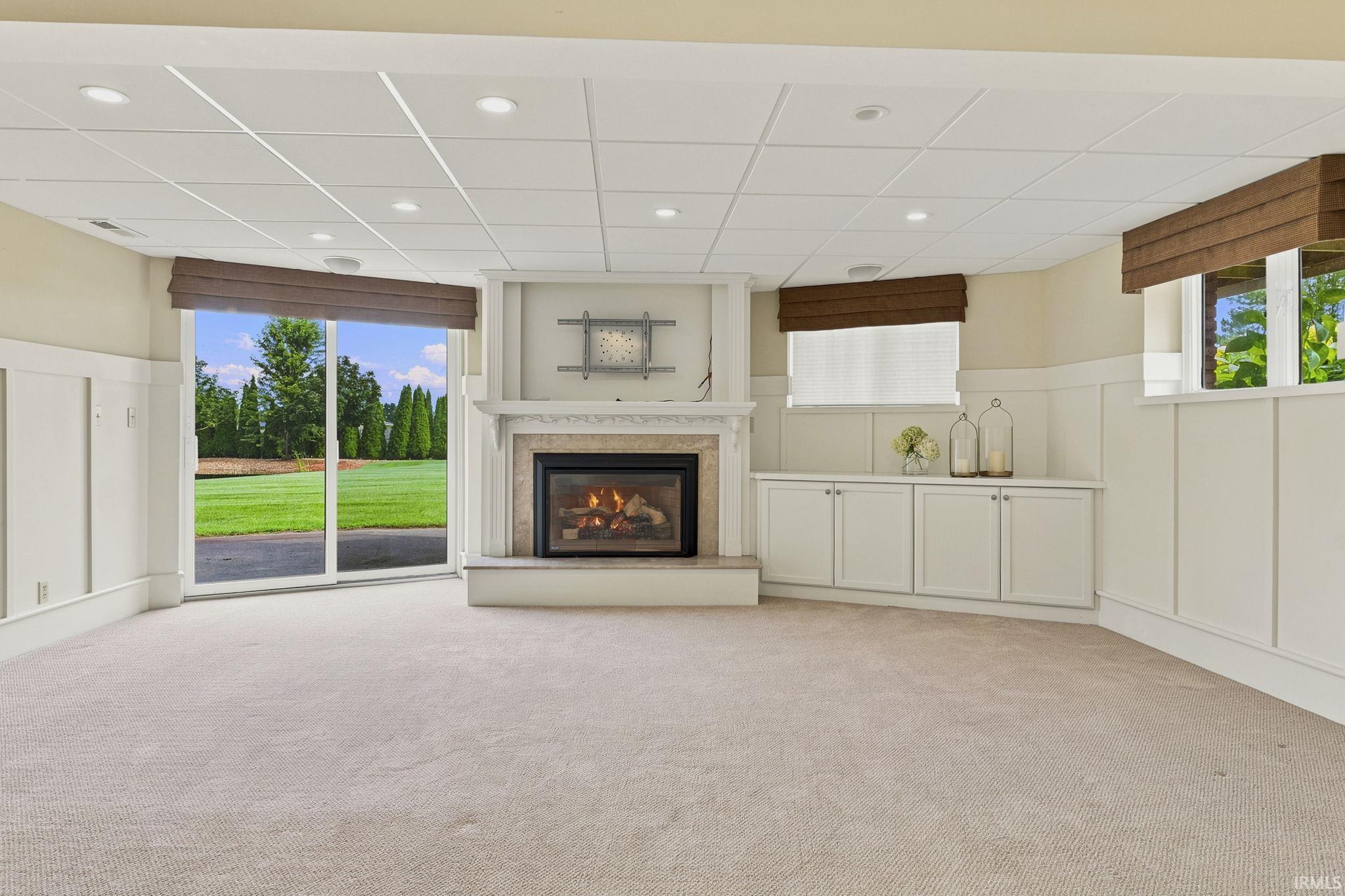 Spacious walk-out lower-level family room featuring a fireplace, custom built-in storage, and abundant living space.