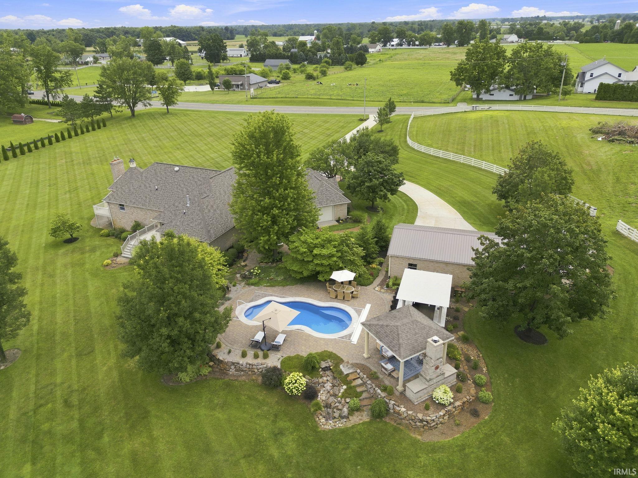 Aerial view highlighting the estate, resort-style pool, and beautifully landscaped grounds.