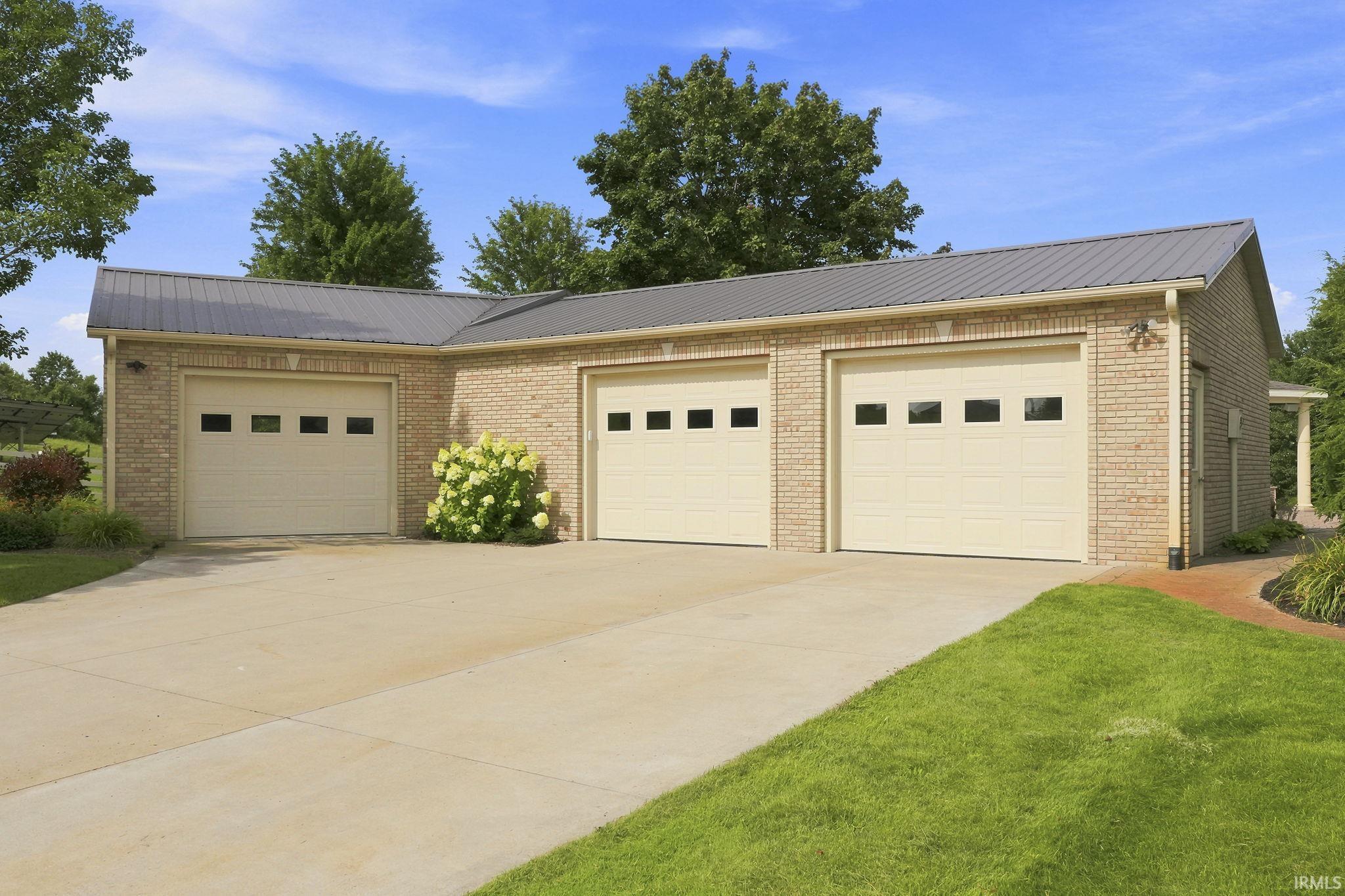 Versatile heated and cooled workshop offering three additional vehicle bays, epoxy flooring, and a custom-built work area.