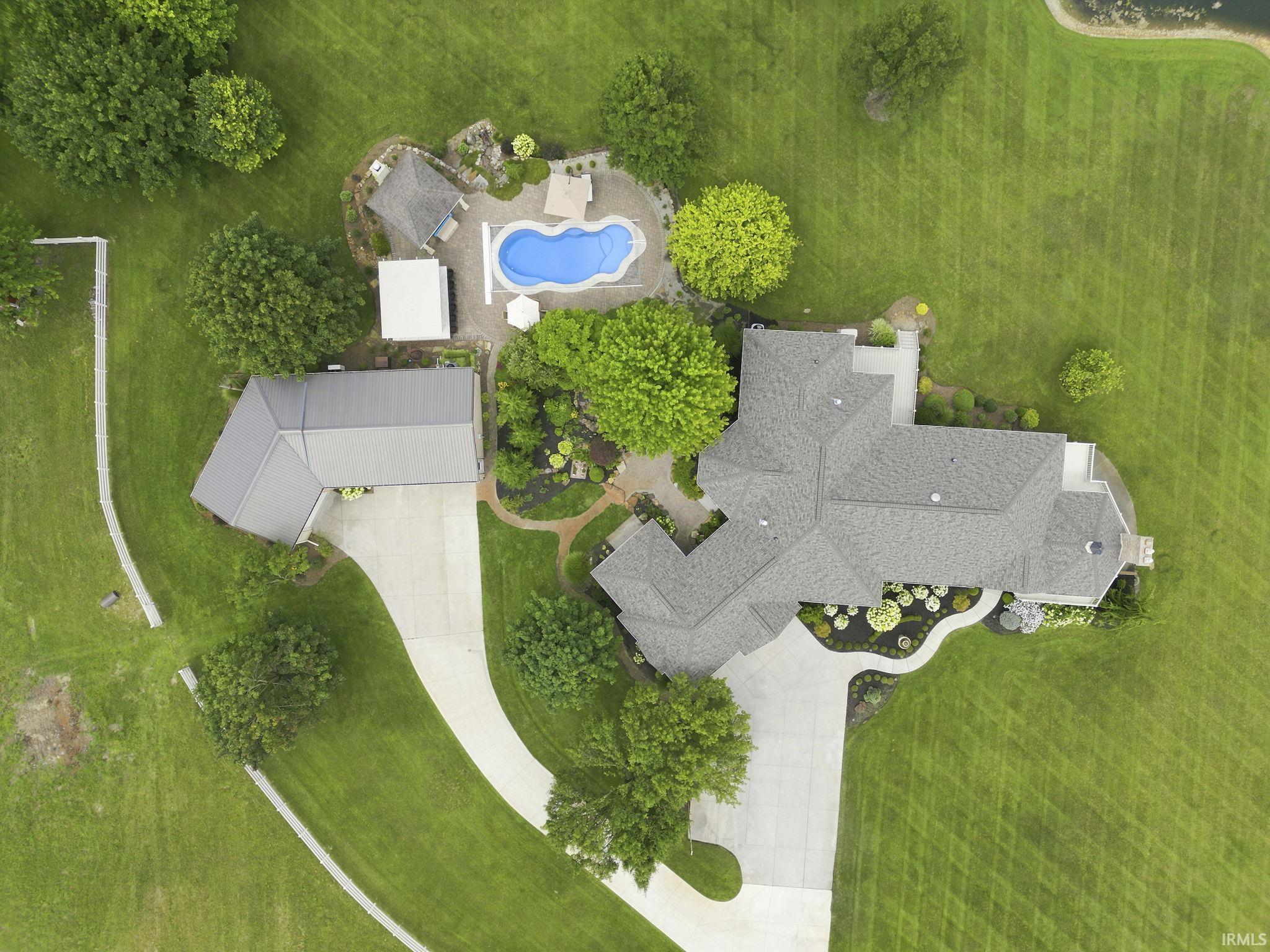 Aerial view highlighting the estate, resort-style pool, and beautifully landscaped grounds.