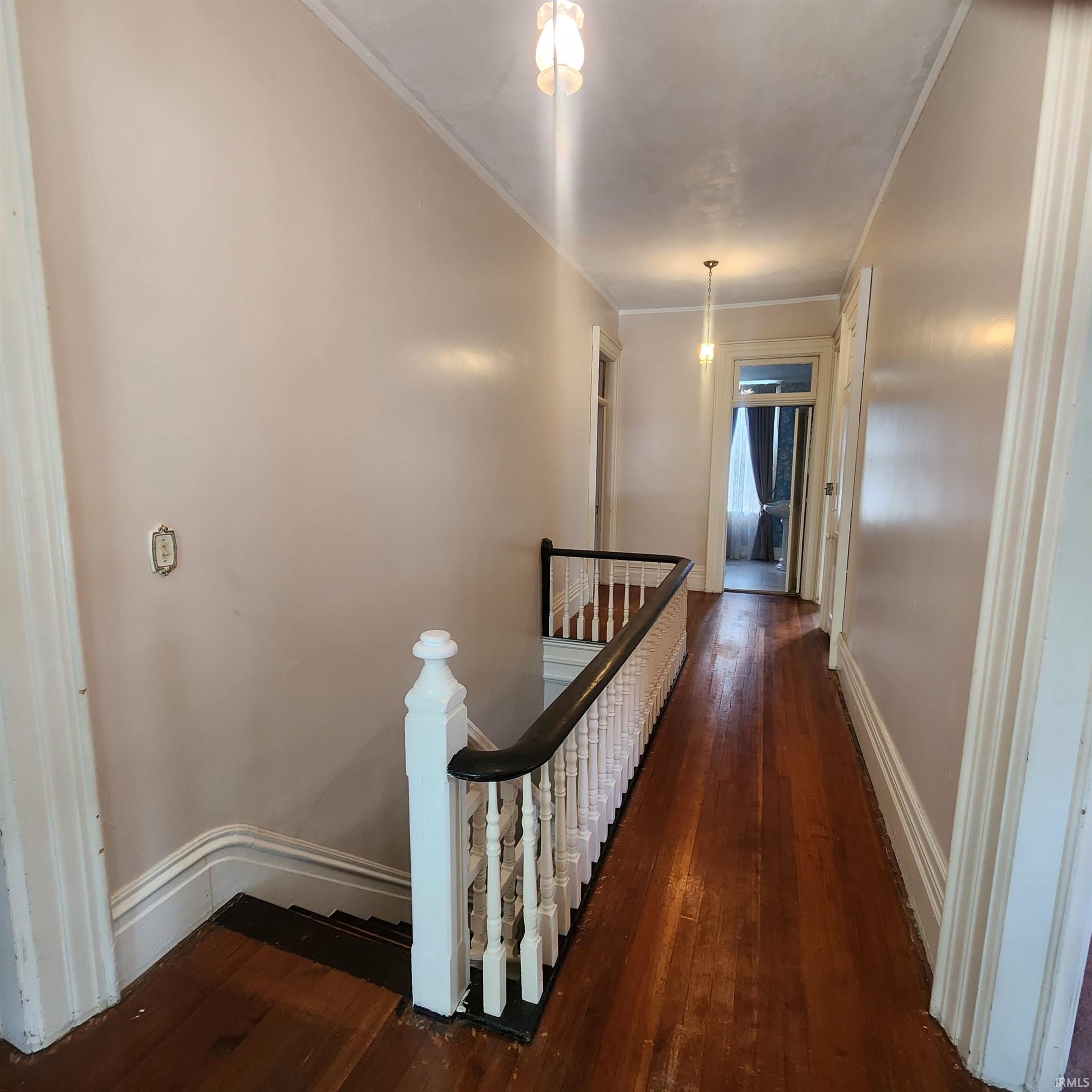 Hallway with wood-finish flooring and light-toned walls