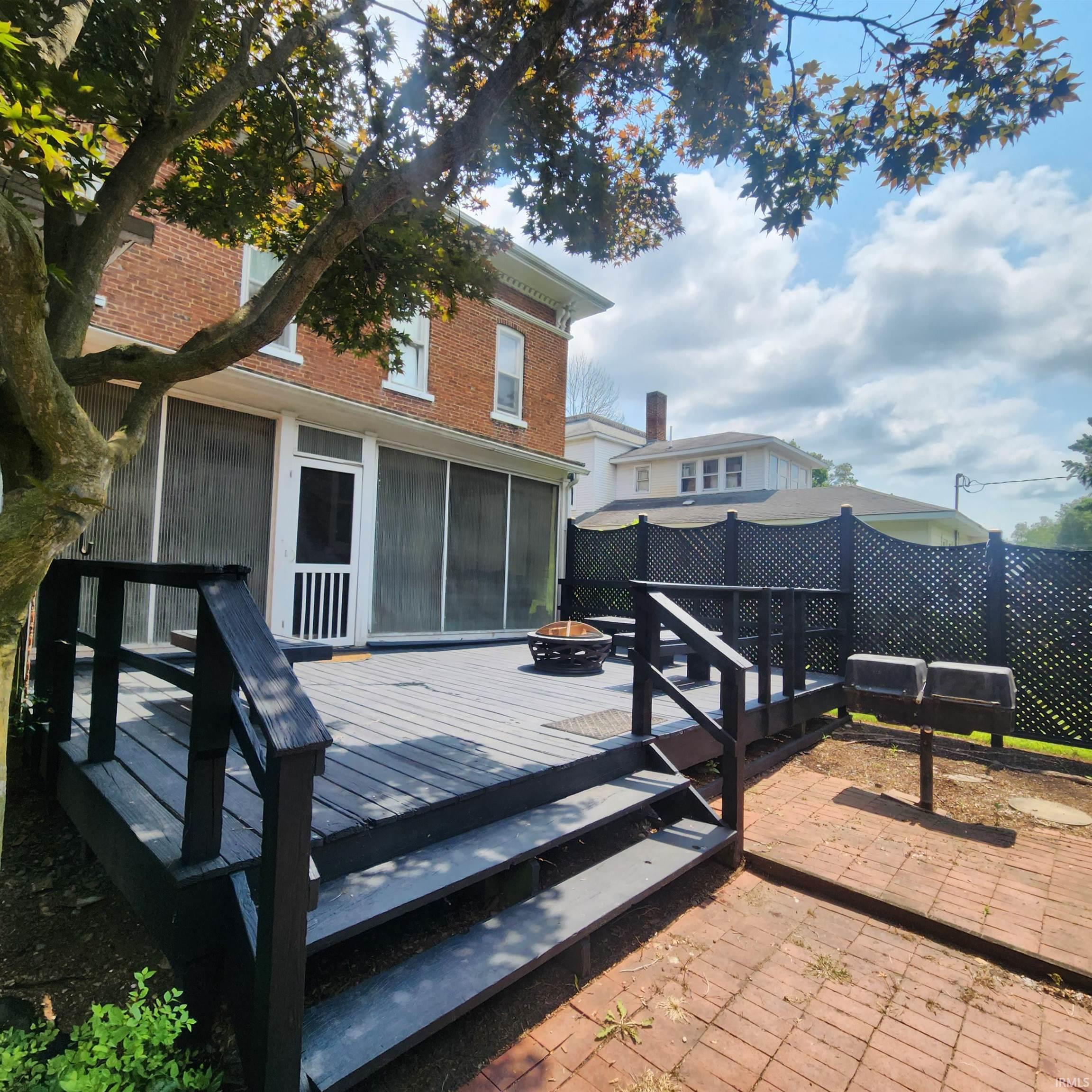 Spacious multi-level deck with steps leading to a brick paver patio