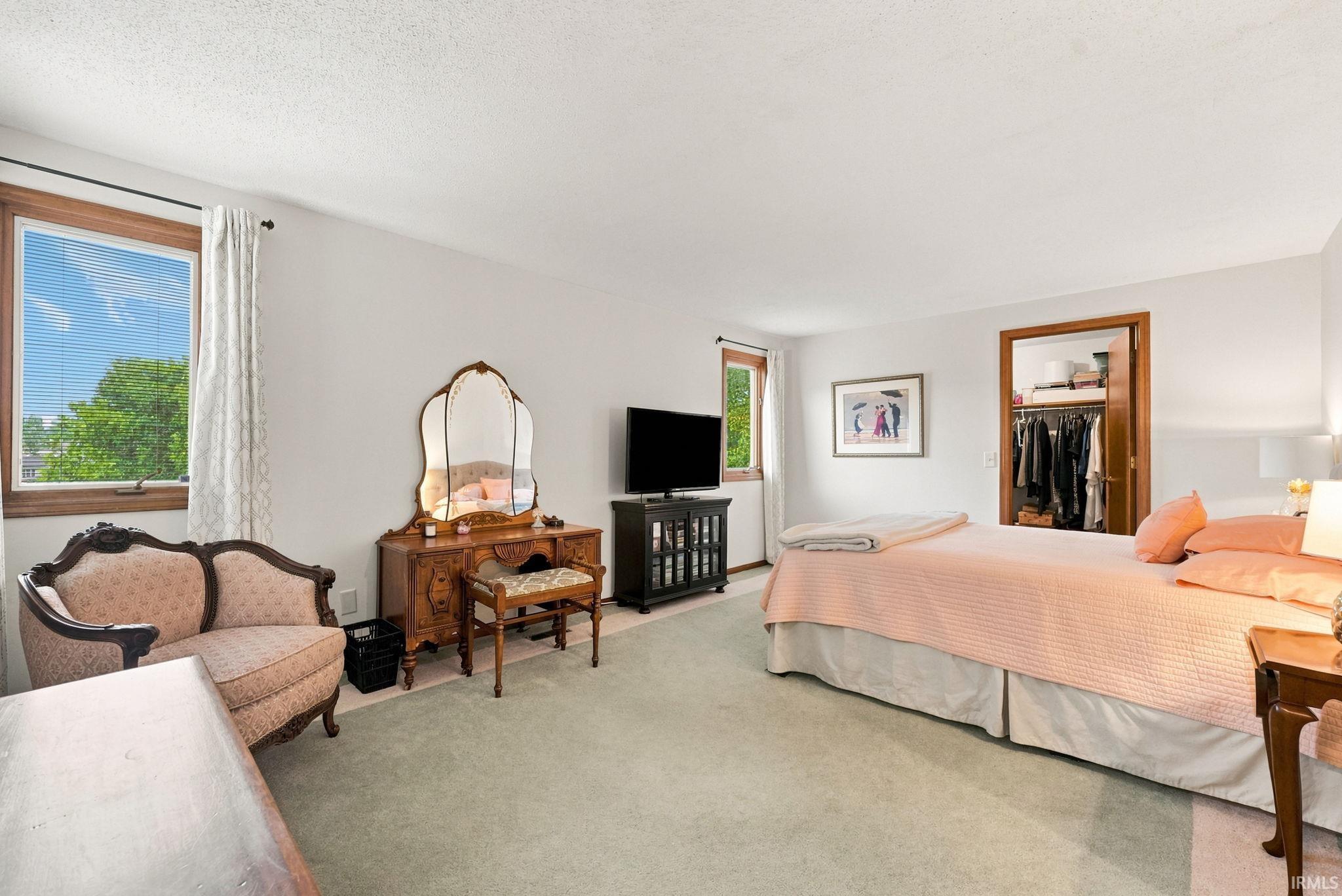 Bedroom featuring light-colored walls and soft green carpeting
