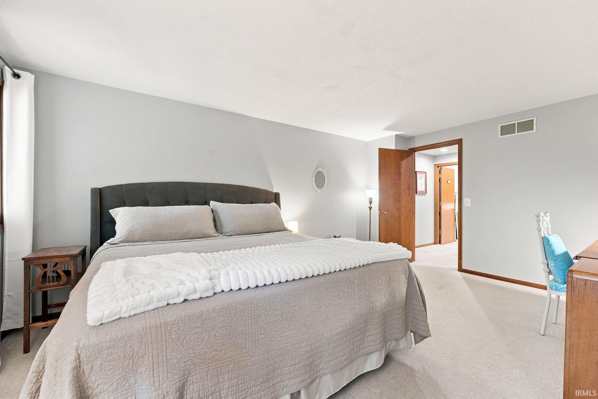 Spacious room featuring light-colored carpet flooring and light gray walls