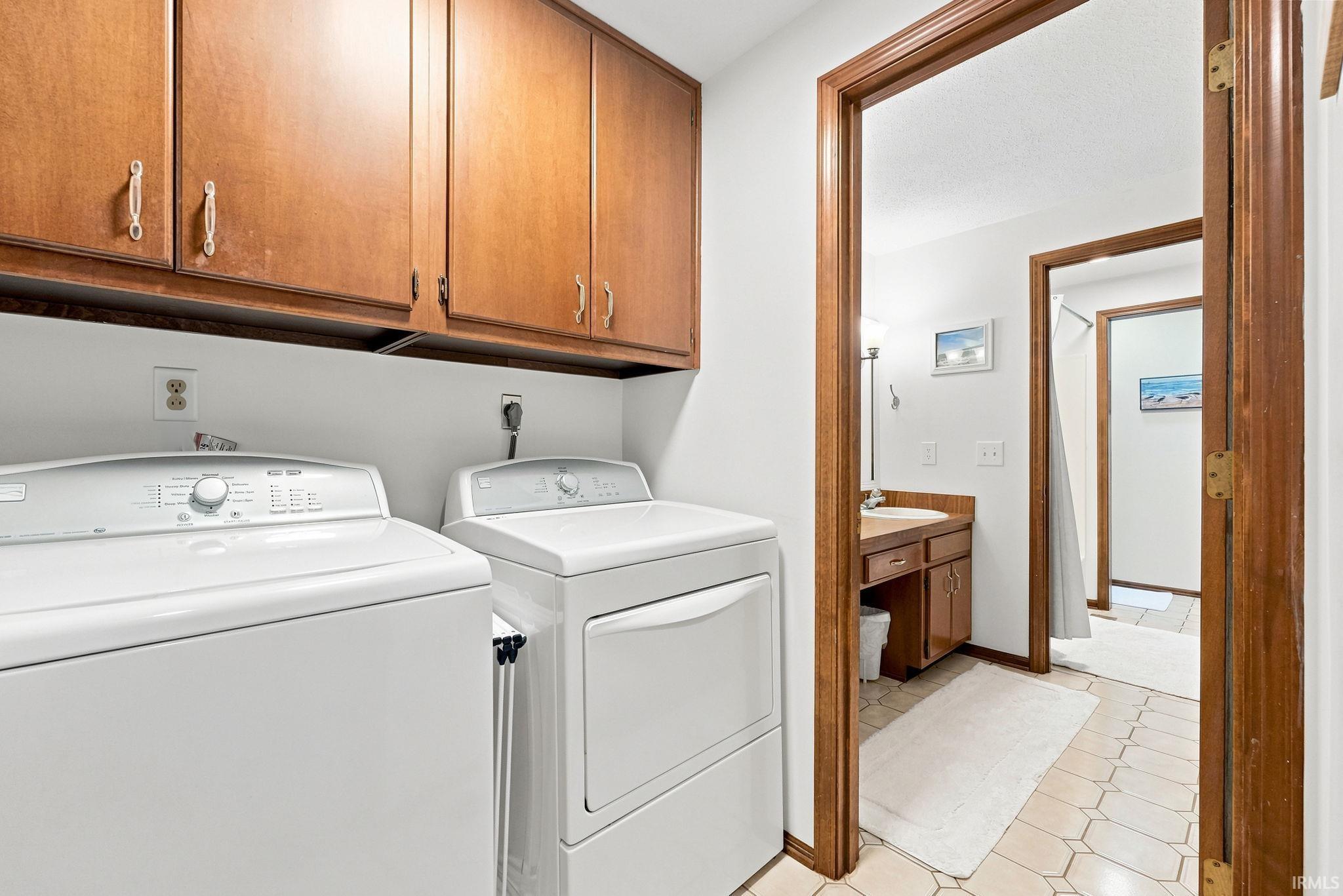 Dedicated laundry area featuring upper wood cabinetry and utility hookups