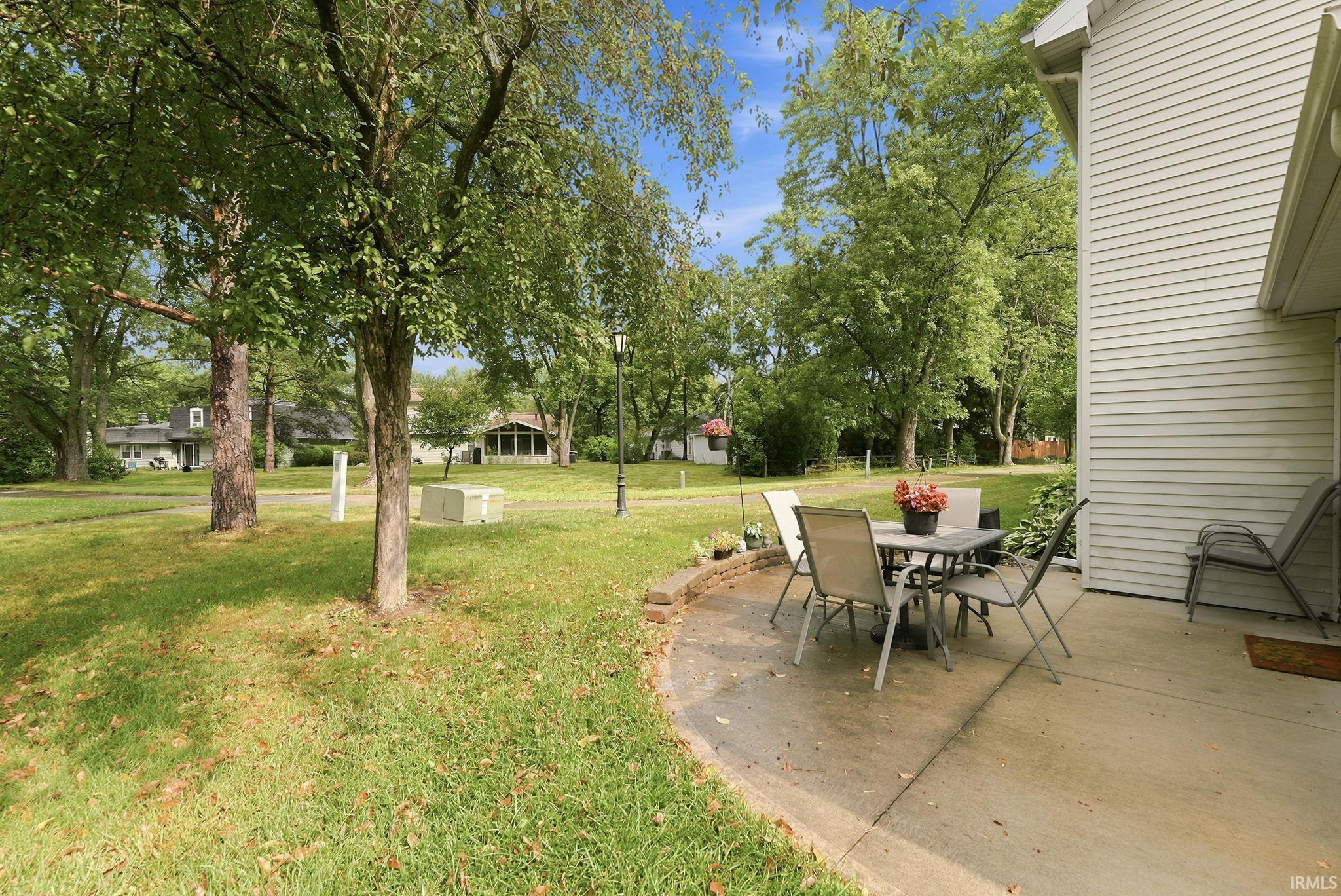 Concrete patio area bordered by a low brick wall