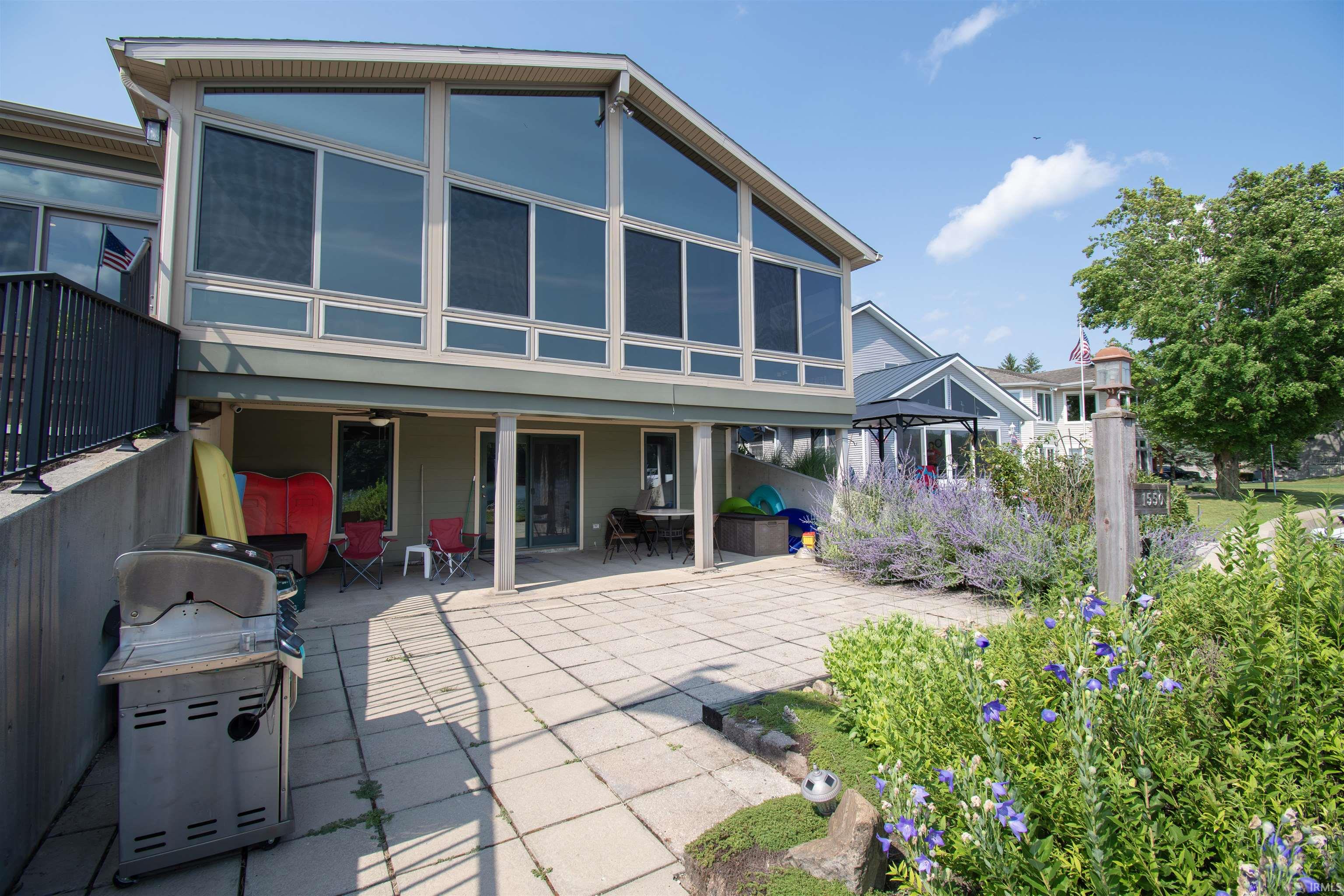 Multi-level exterior featuring a large upper-level sunroom with expansive windows