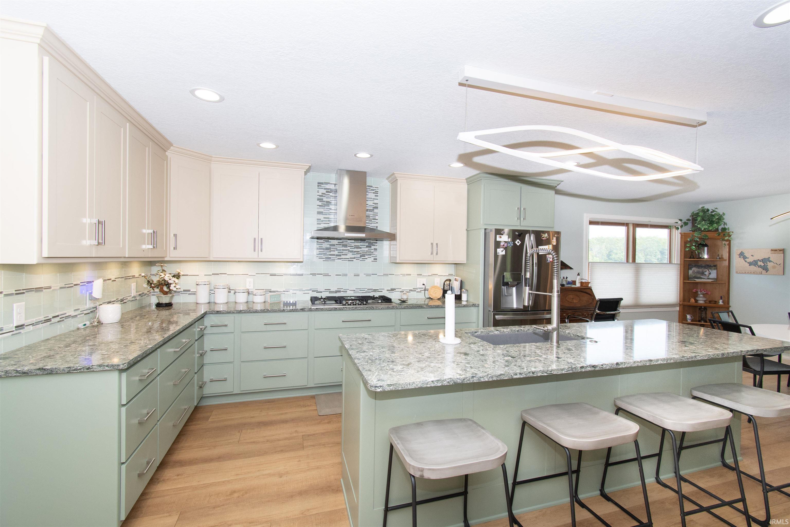 Kitchen featuring an expansive island with an undermount sink and seating