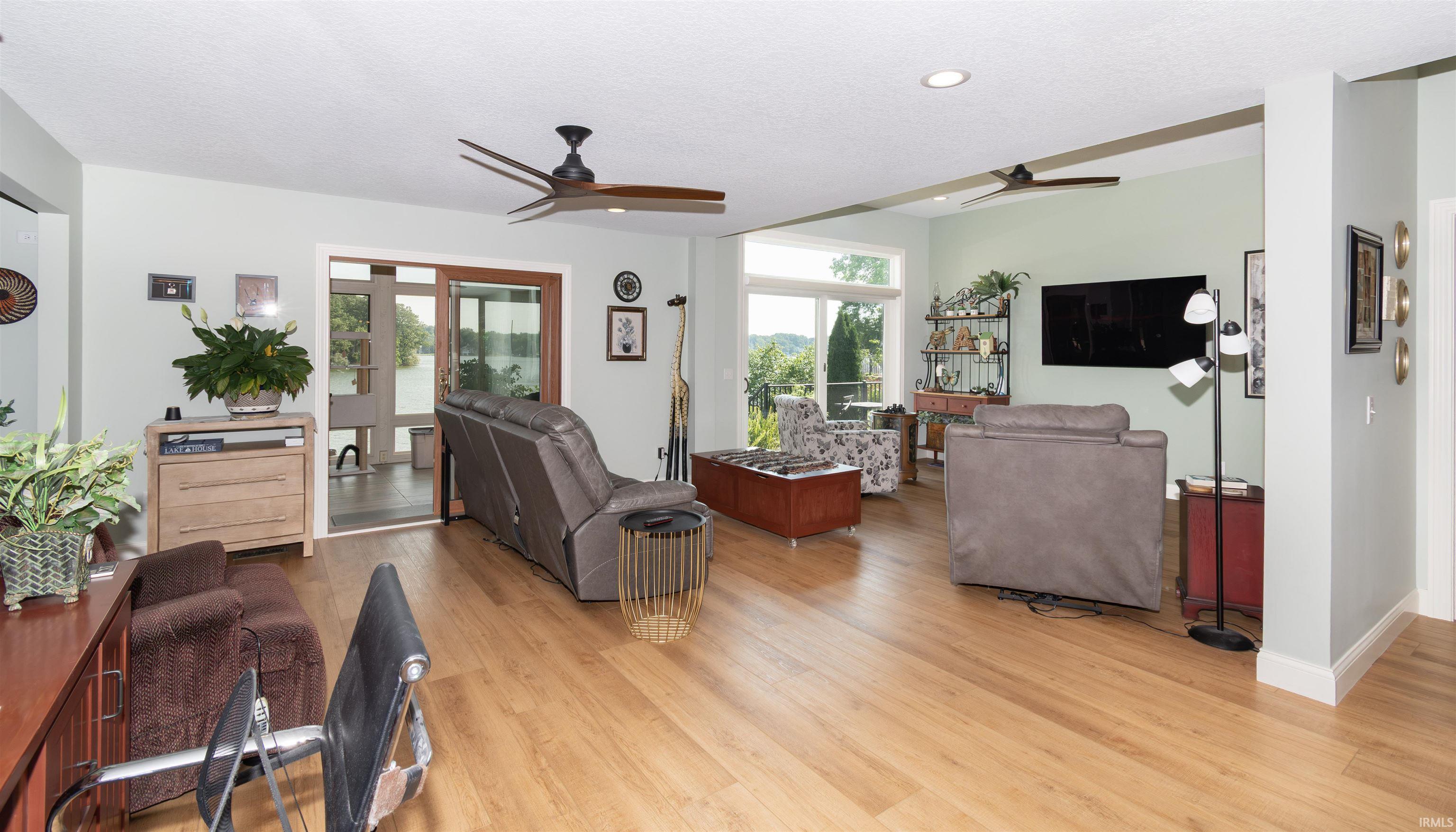 Open concept living area featuring wood-finish flooring, recessed lighting, and dual ceiling fans