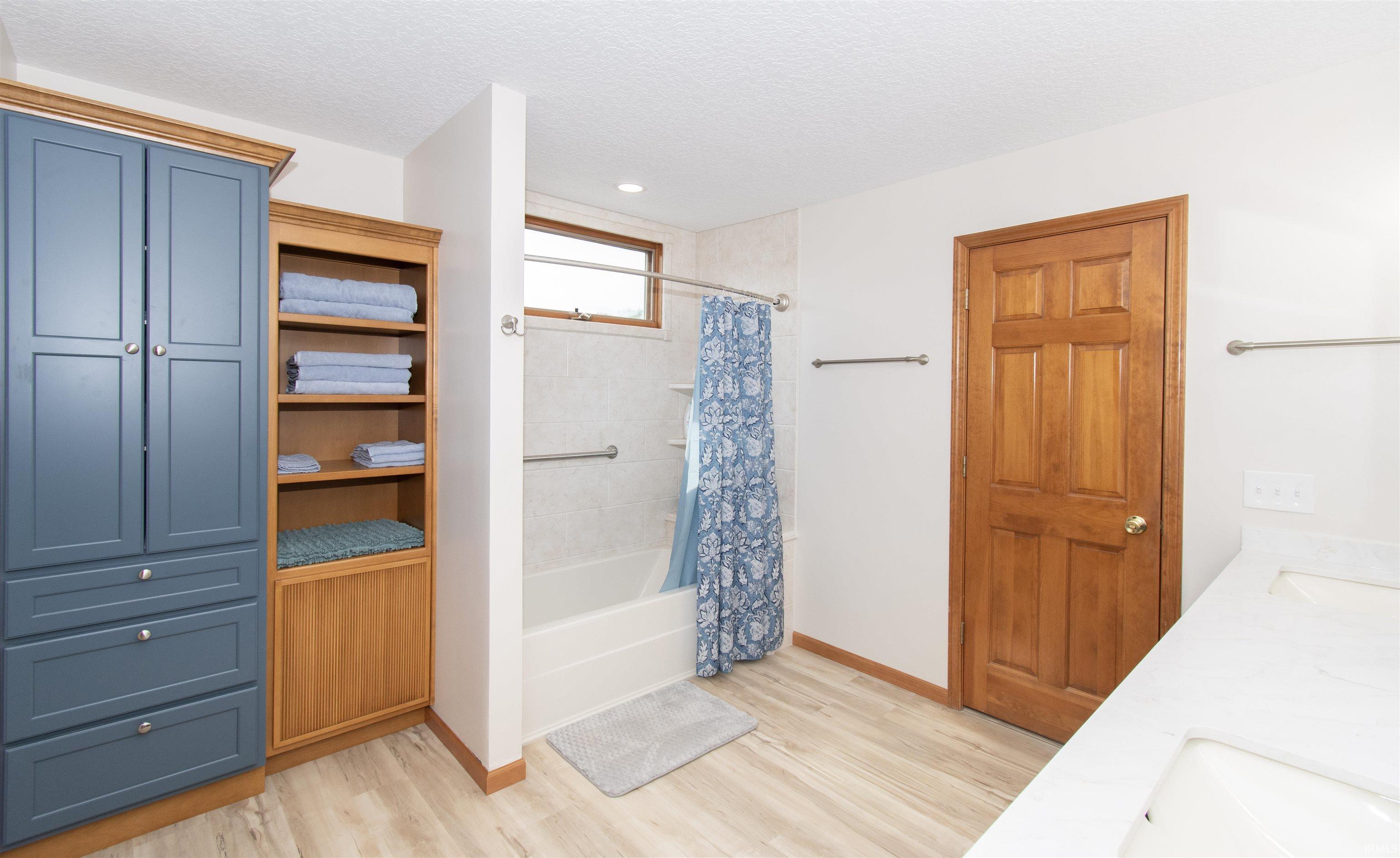 Bathroom featuring wood-finish flooring and a double vanity with integrated sinks
