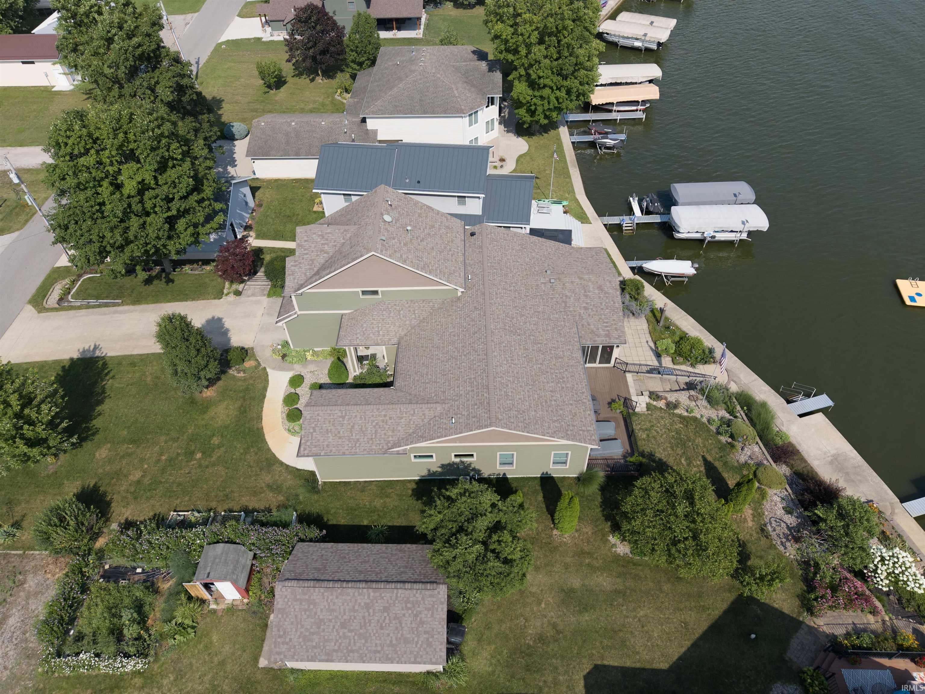 Waterfront property featuring a private dock system, concrete seawall, and multiple levels of outdoor living space