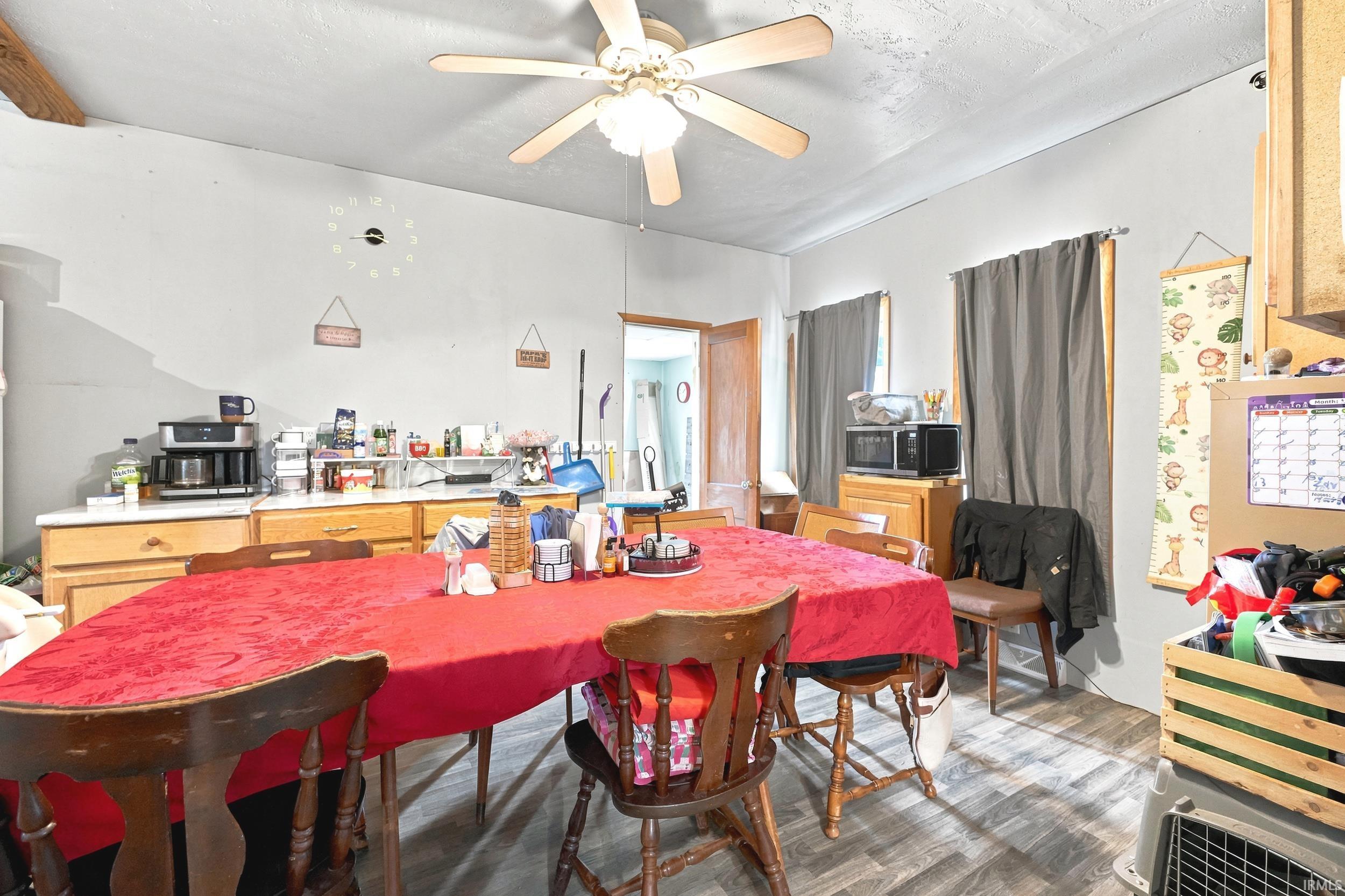 Dining area with wood-finish flooring, overhead ceiling fan, and light-toned walls