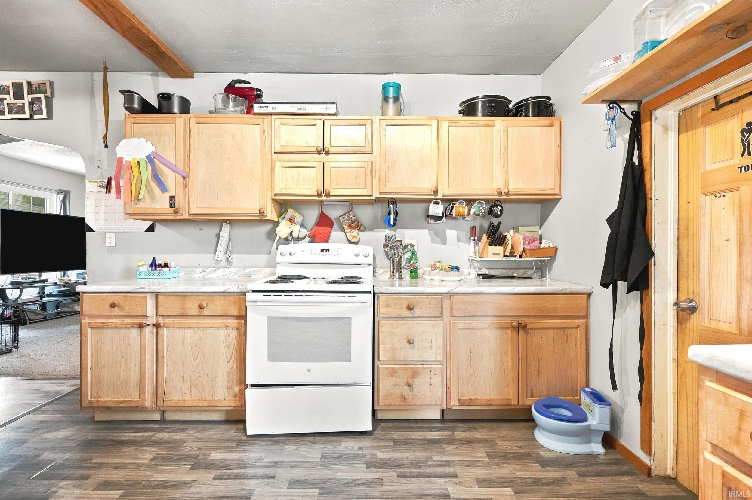Kitchen featuring wood-finish flooring, light-toned cabinetry, white countertops, and a white freestanding range