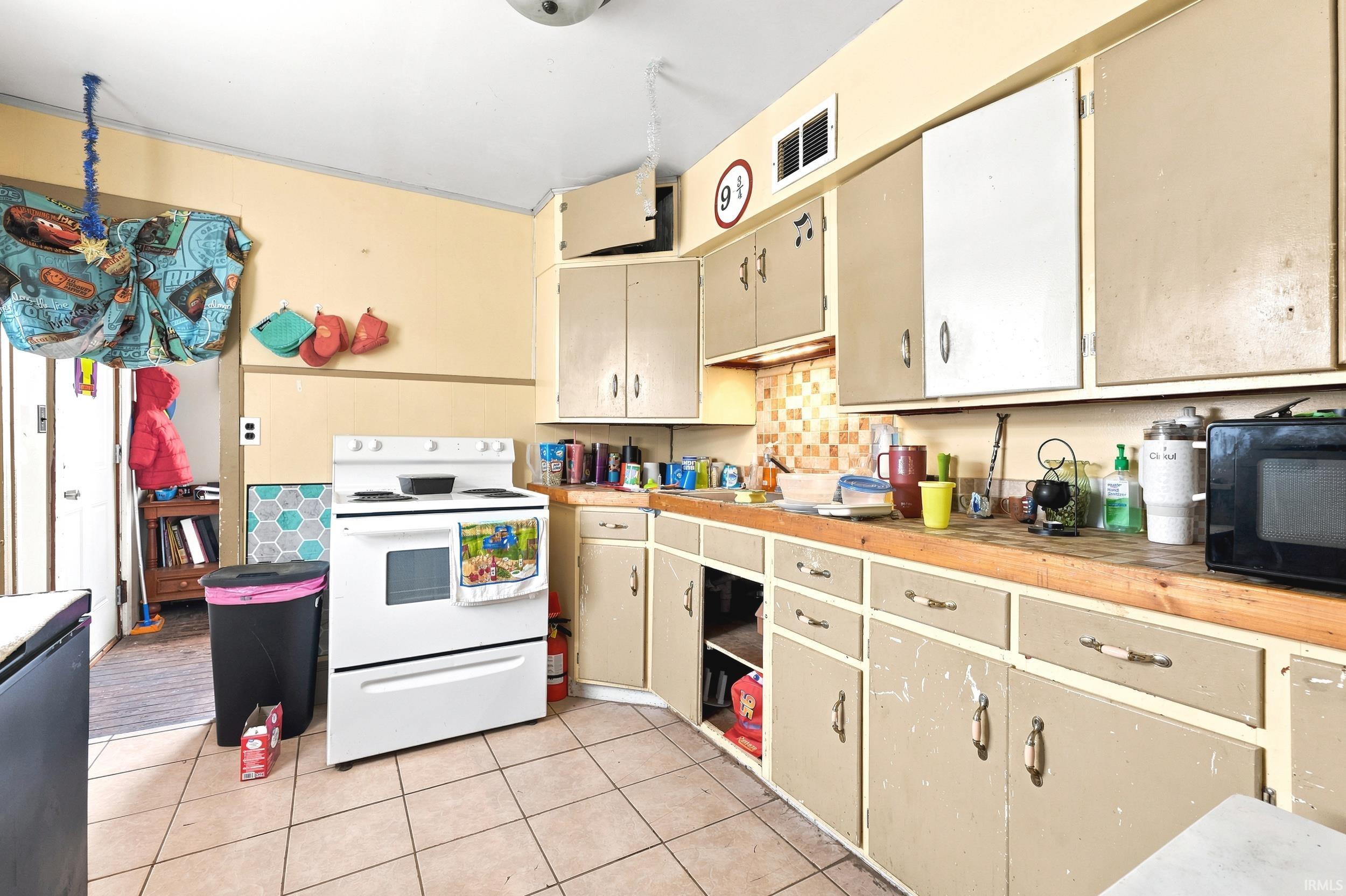 Kitchen with tile flooring and a white electric range
