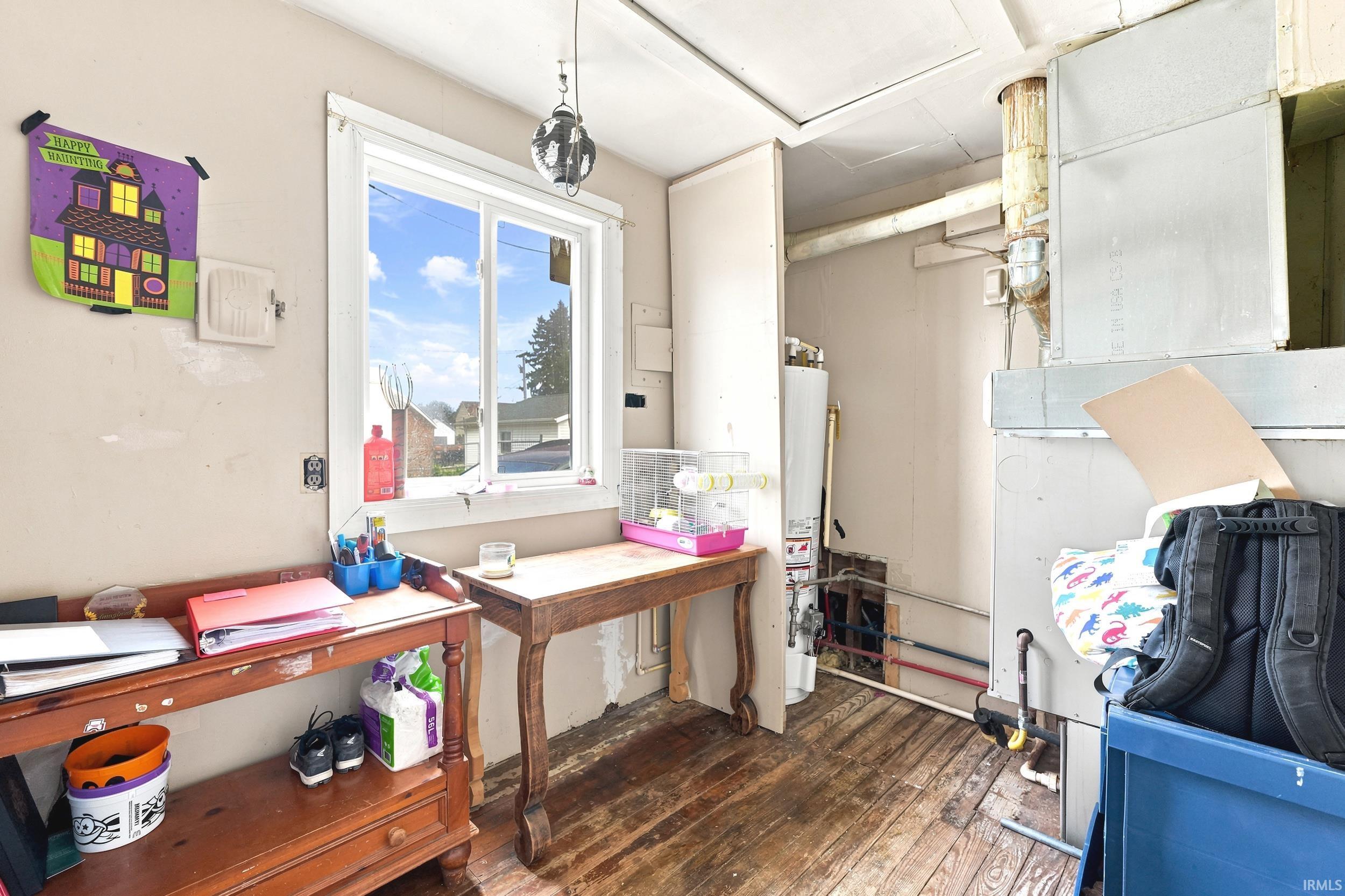 Interior space with a double-pane window and exposed wood plank flooring