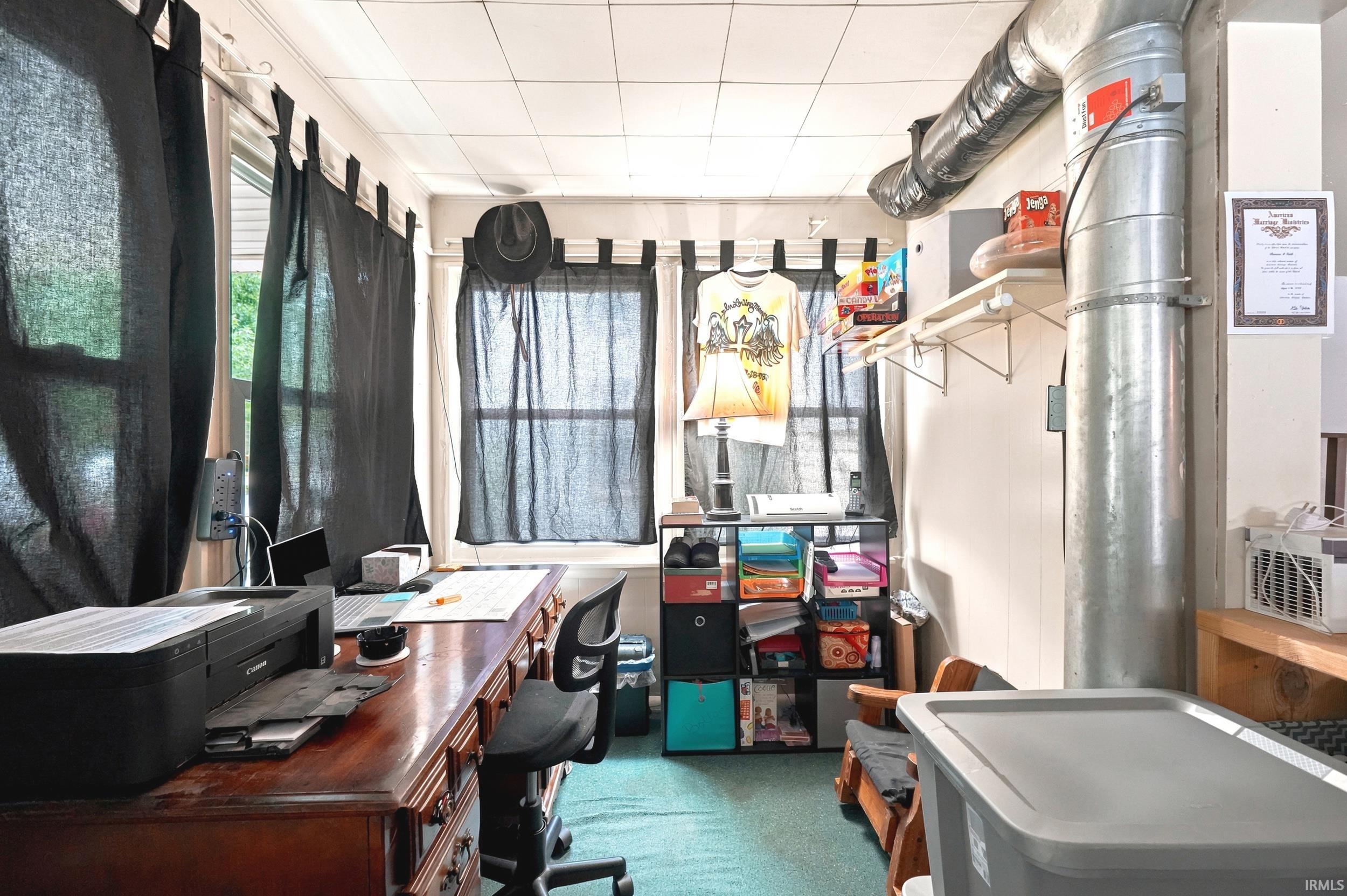 Versatile interior space featuring multiple windows, exposed ductwork, white walls, and a dropped ceiling