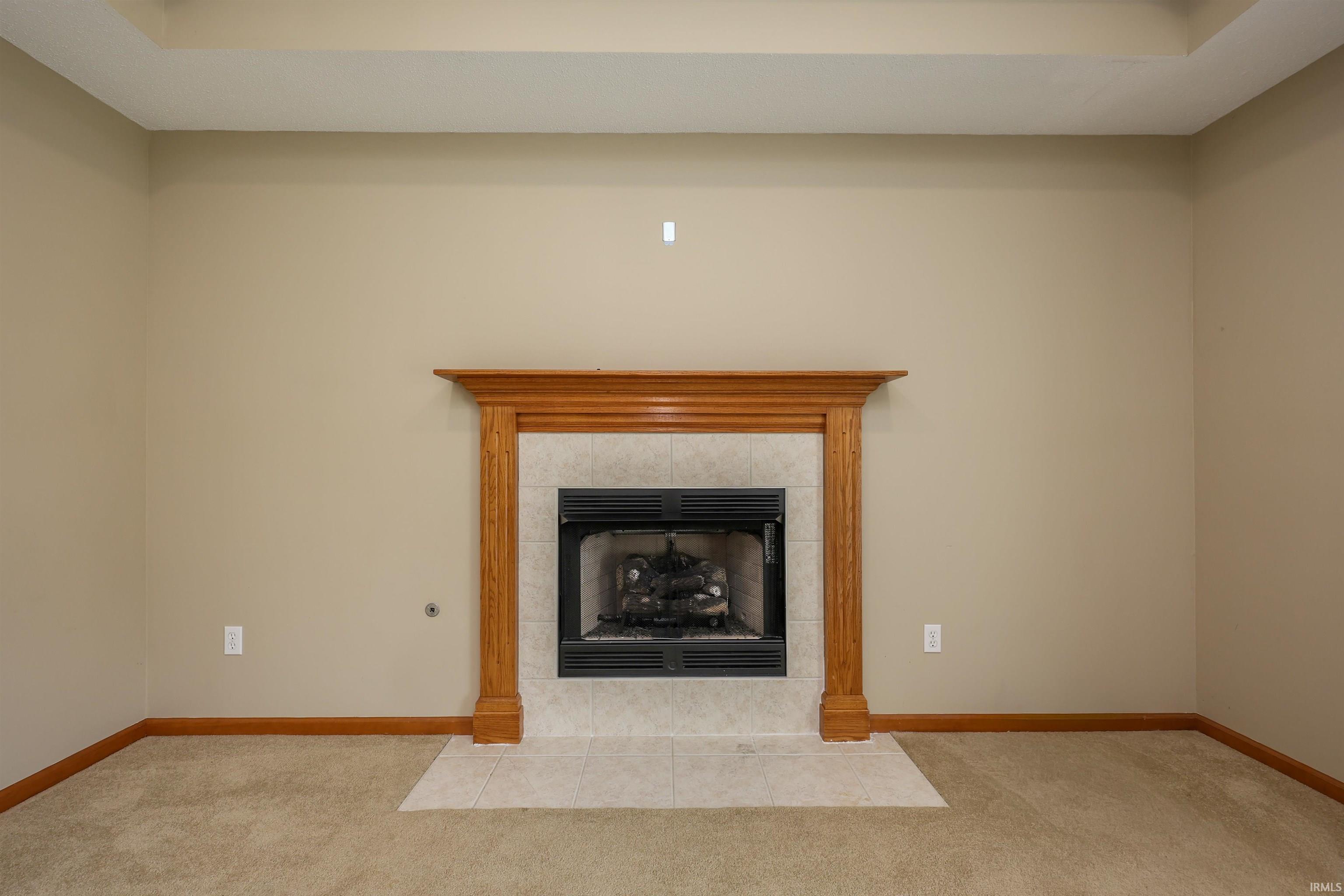 Fireplace with a wood mantel and tile surround