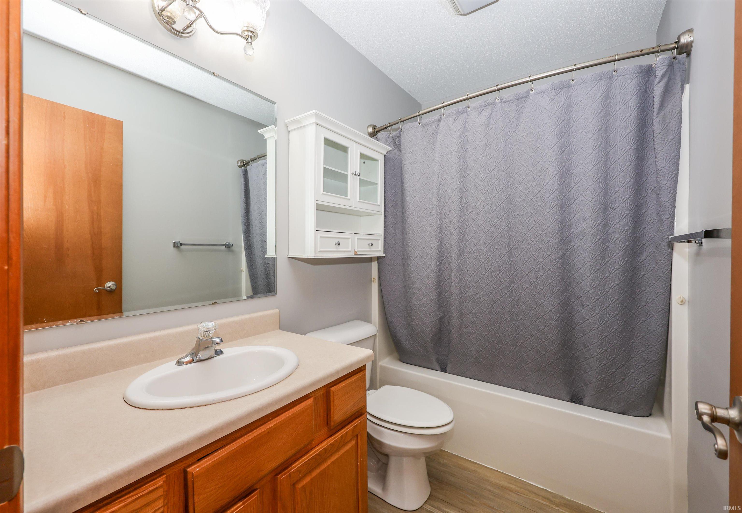 Bathroom featuring a built-in vanity with wood-finish cabinetry, an integrated sink, and an extended countertop