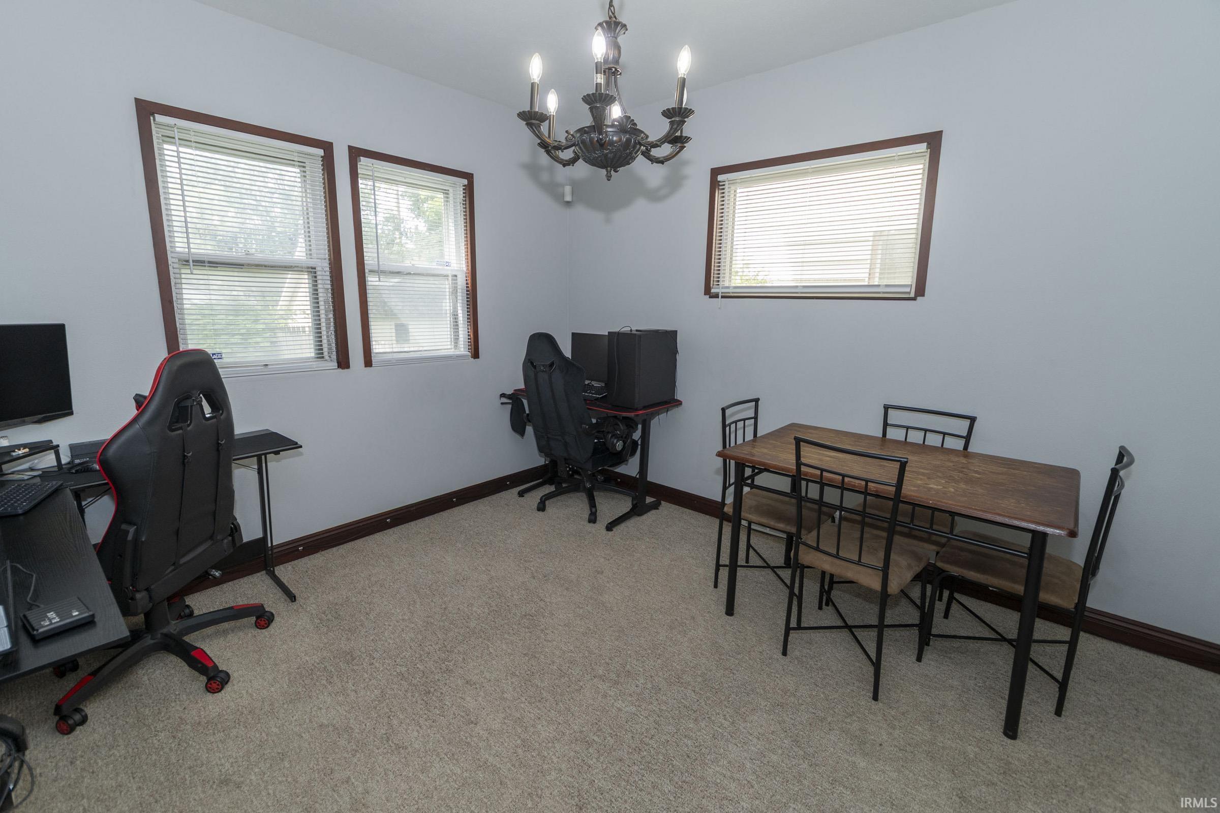 Room featuring neutral carpeting, light-toned walls, and dark wood trim