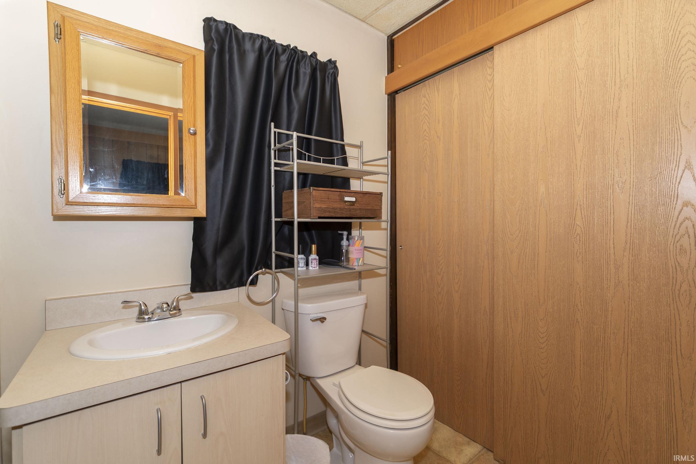 Bathroom featuring a vanity with an integrated sink, wood-finish cabinetry, and a mirrored medicine cabinet