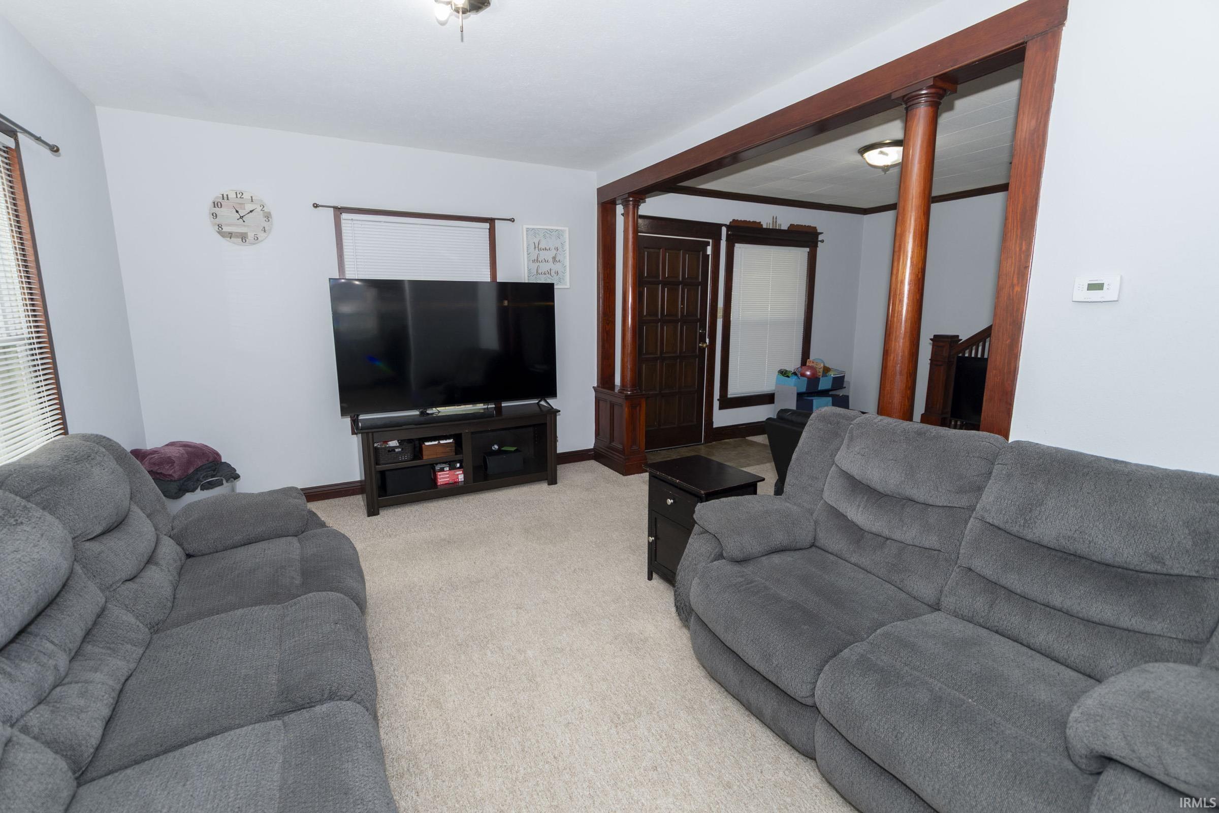 Living area featuring light gray walls and wood-finish trim