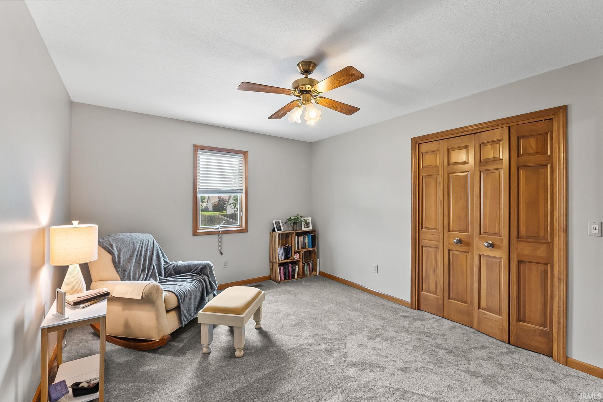 Spacious interior room featuring light gray wall paint and gray carpet flooring