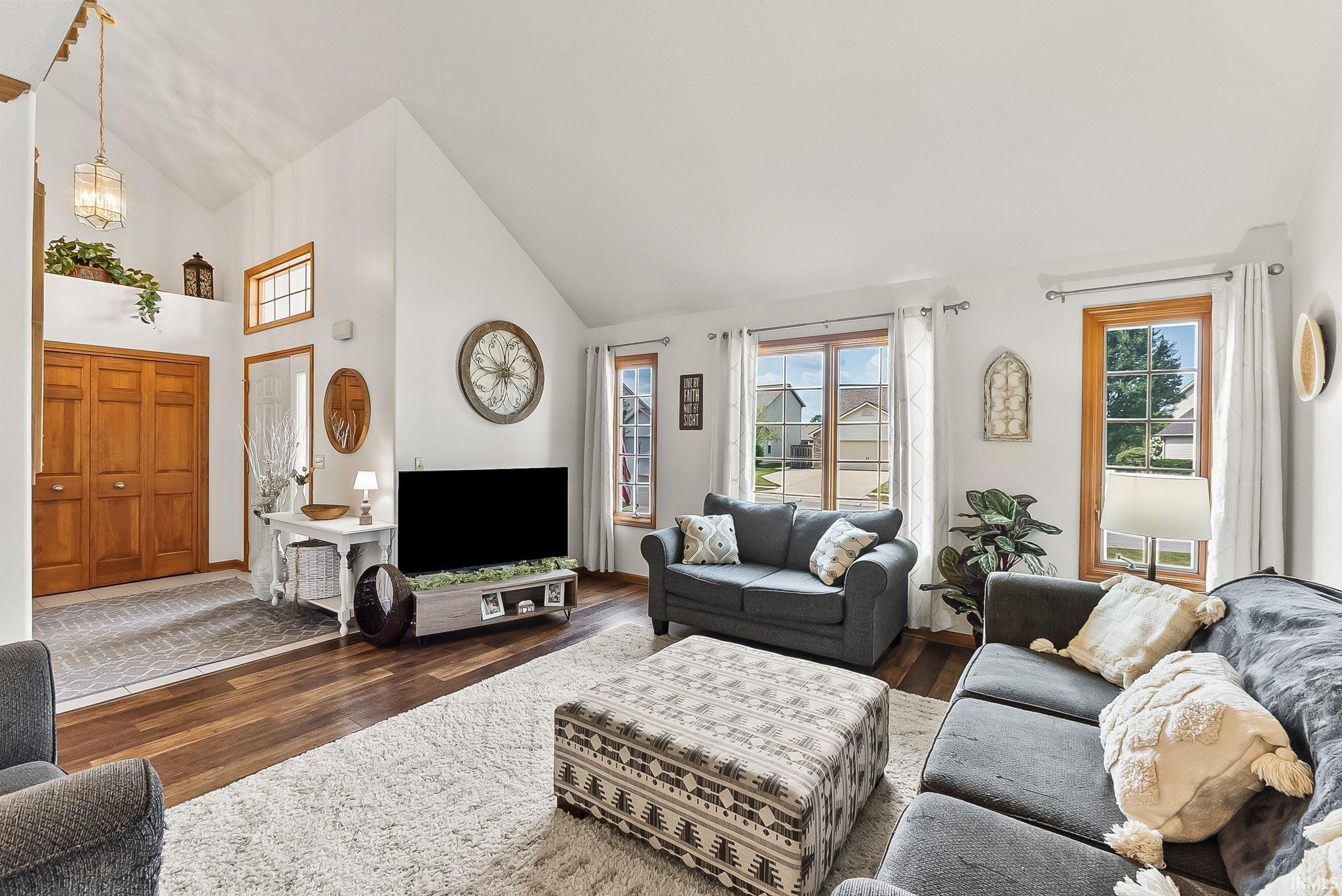 Vaulted ceilings complement wood-finish flooring throughout this living space